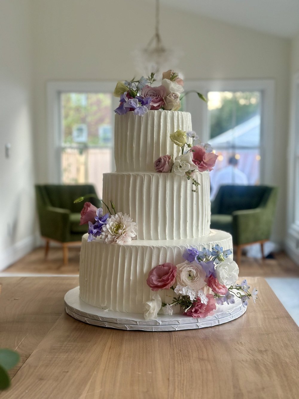 Three-tier white cake with fresh flowers