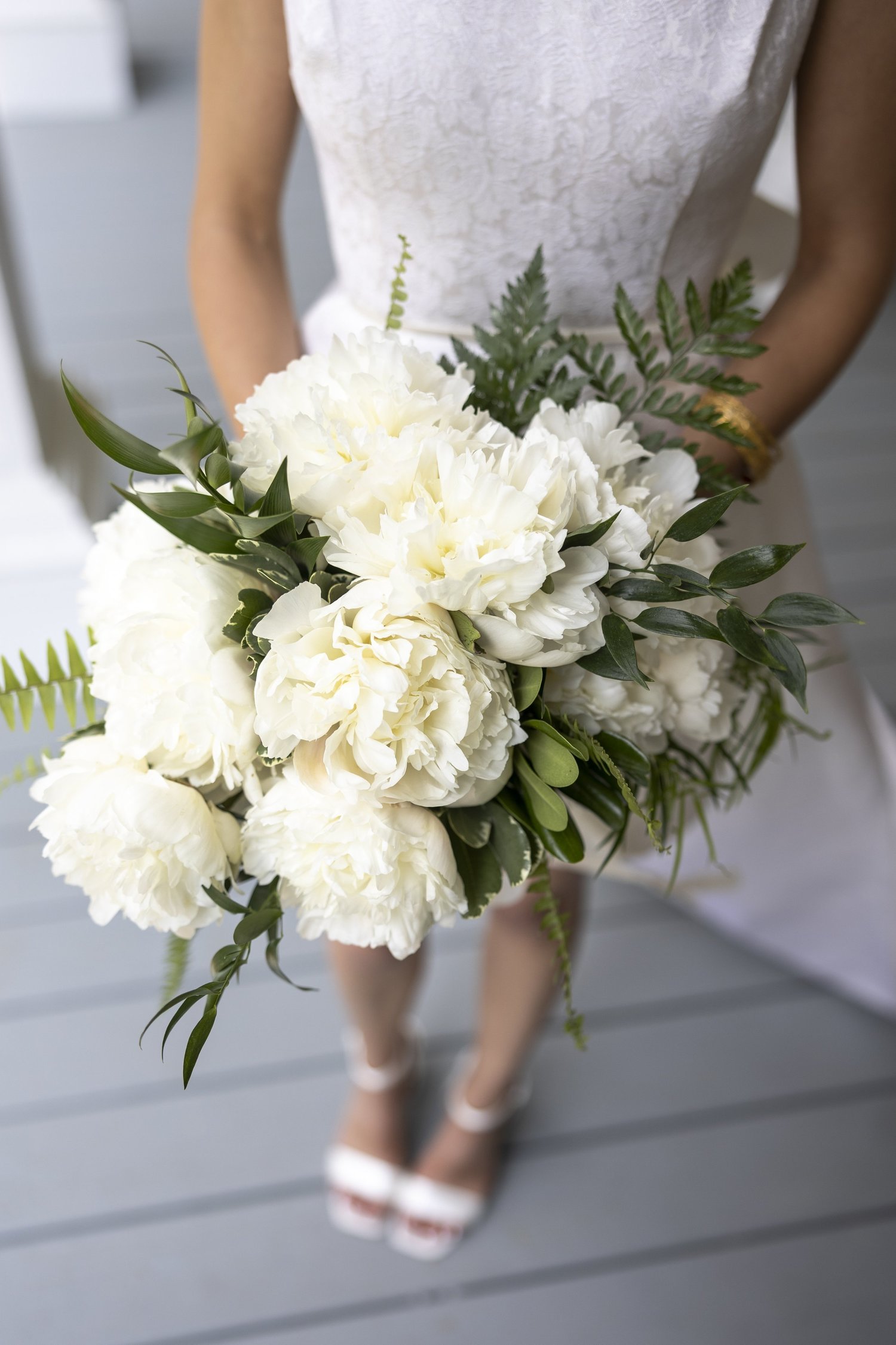 Bride holding a white peony bouquet