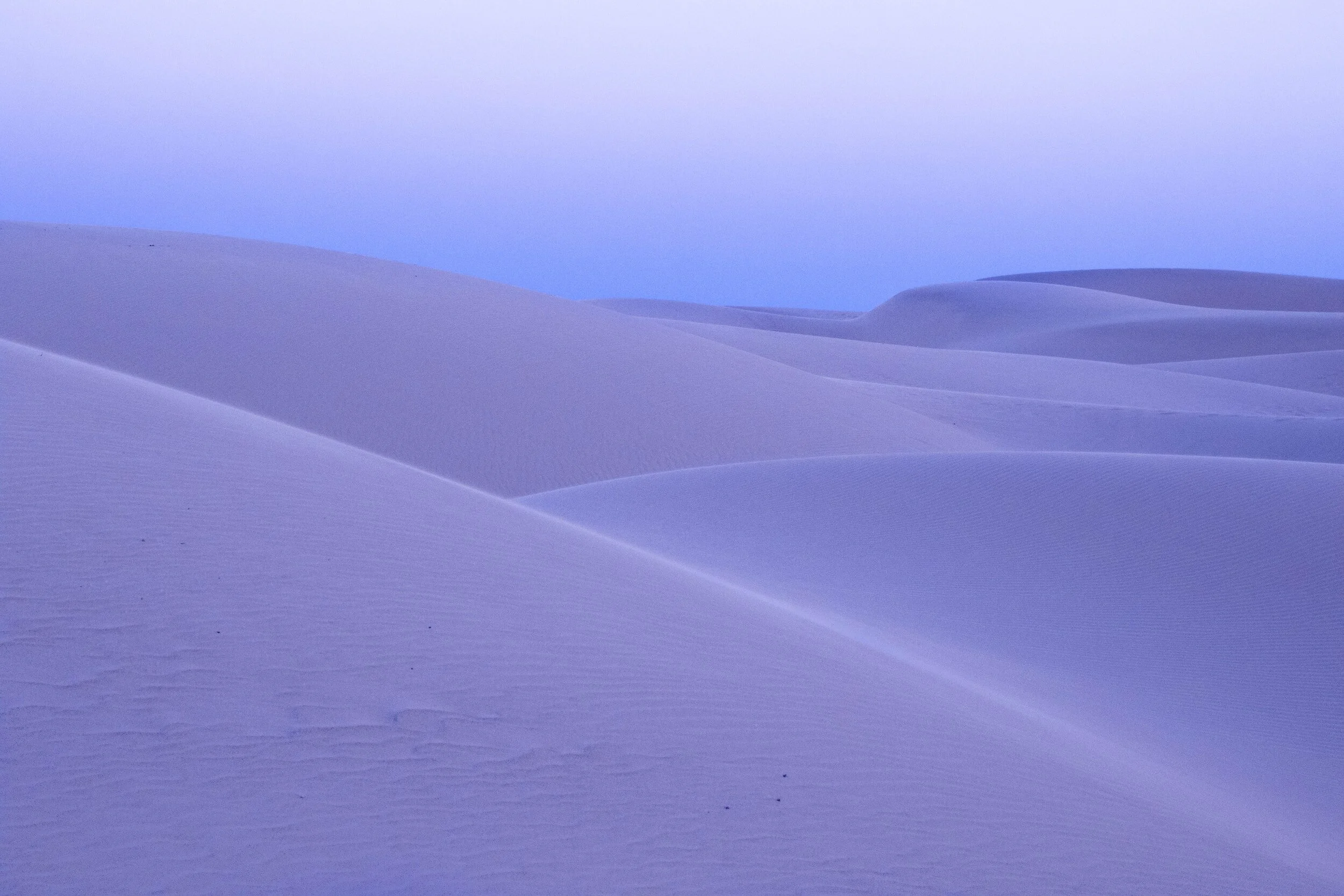 white sand dunes with blue and purple colors