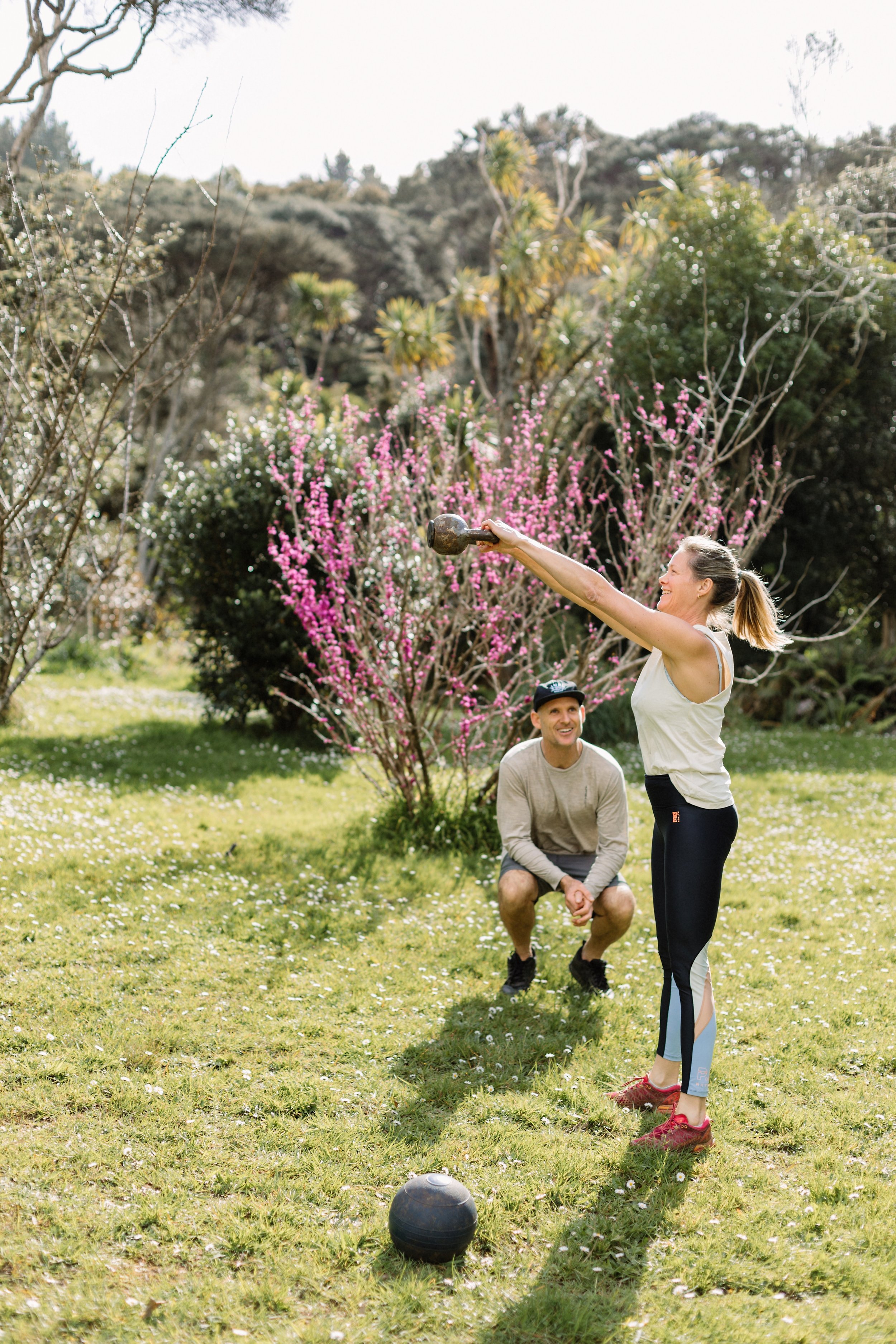 Pesonal trainer Mike Jewell guiding a client through an outdoor workout session, demonstrating exercises and proper technique in a natural setting.
