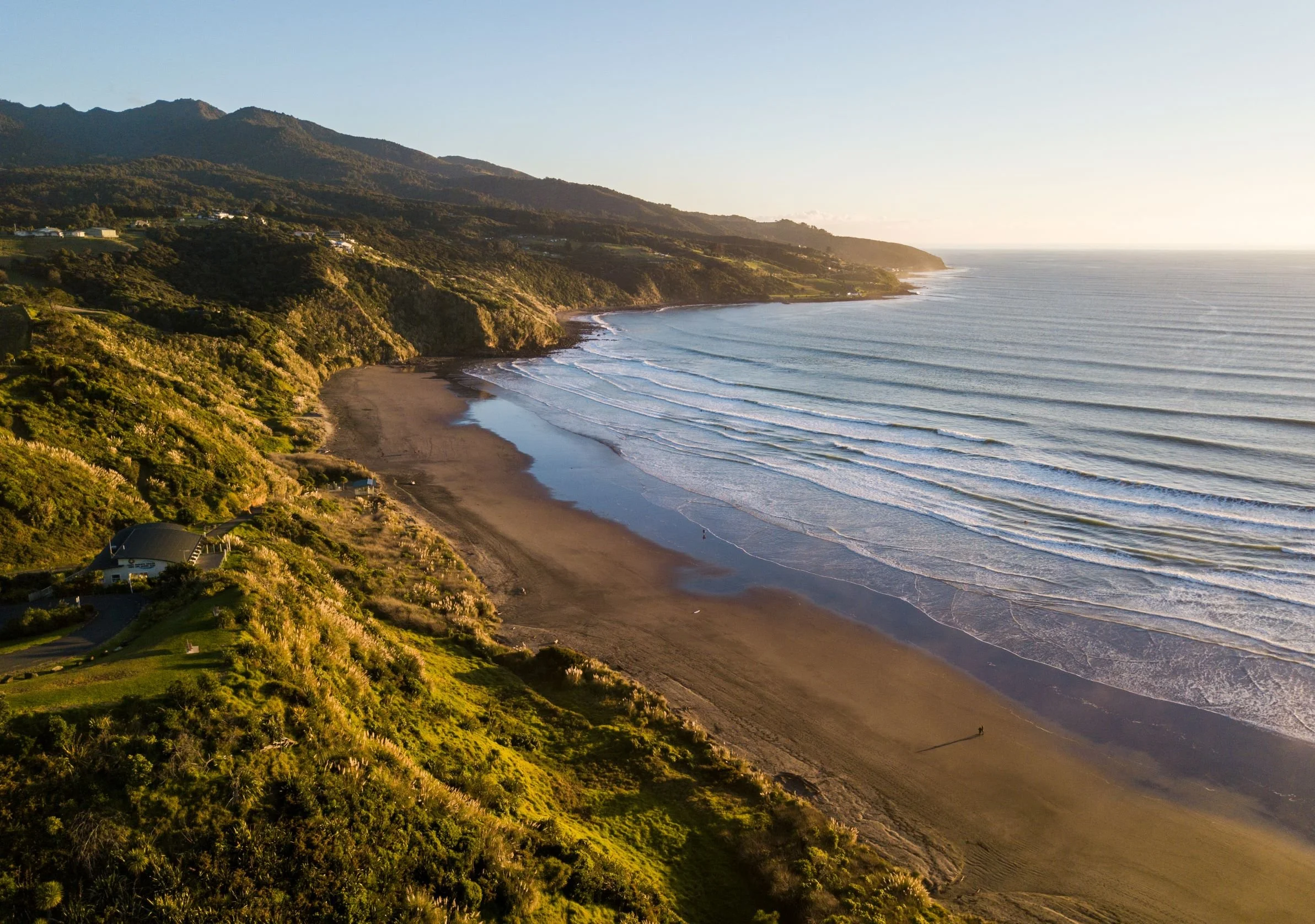 Waves rolling onto Raglan Beach near TrueLife Bodywork, capturing the natural beauty and relaxing atmosphere of the location.