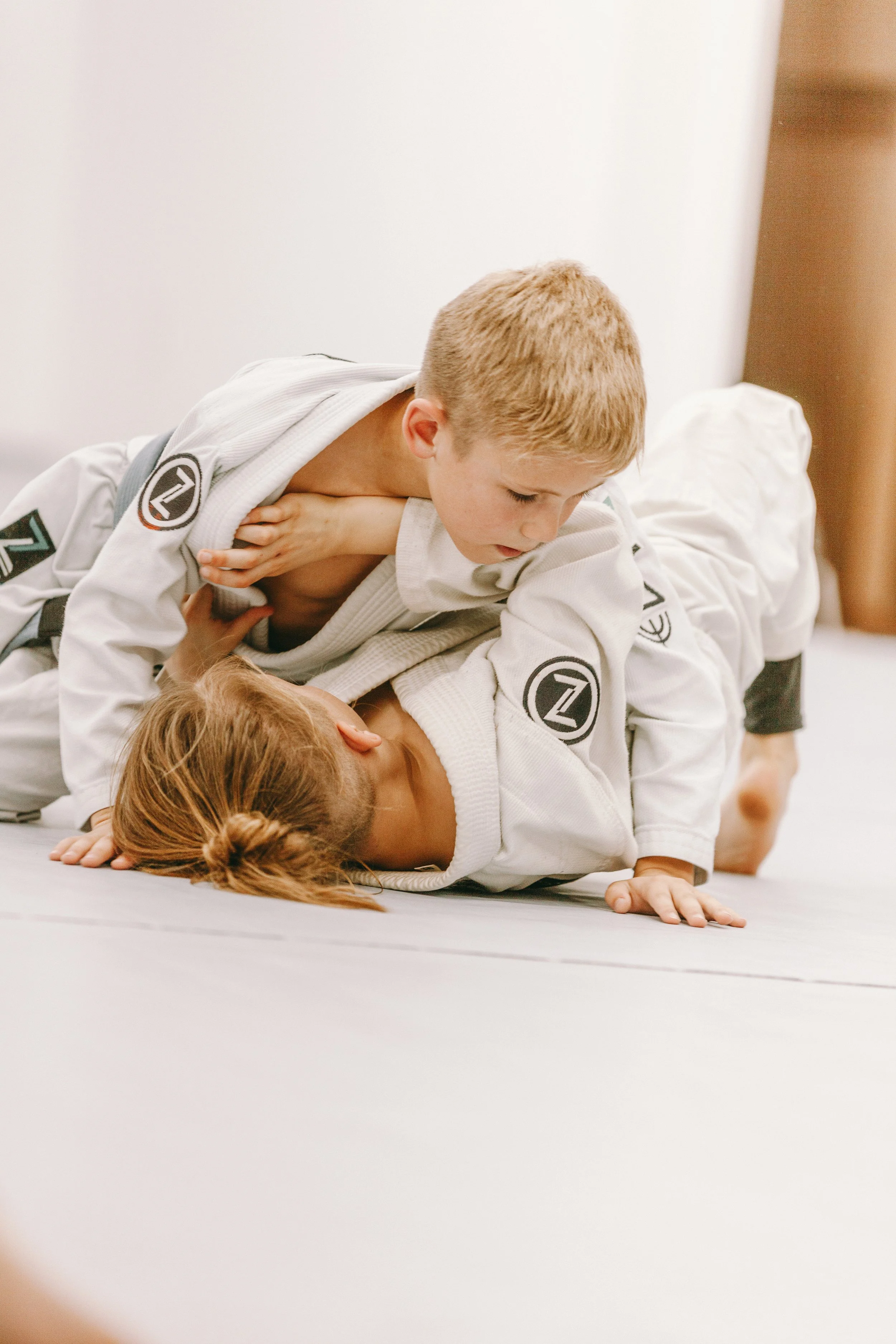 Kids train side control pressure and safety in kids jiu jitsu class at Houzn Jiu Jitsu Academy in Mount Pleasant, SC.