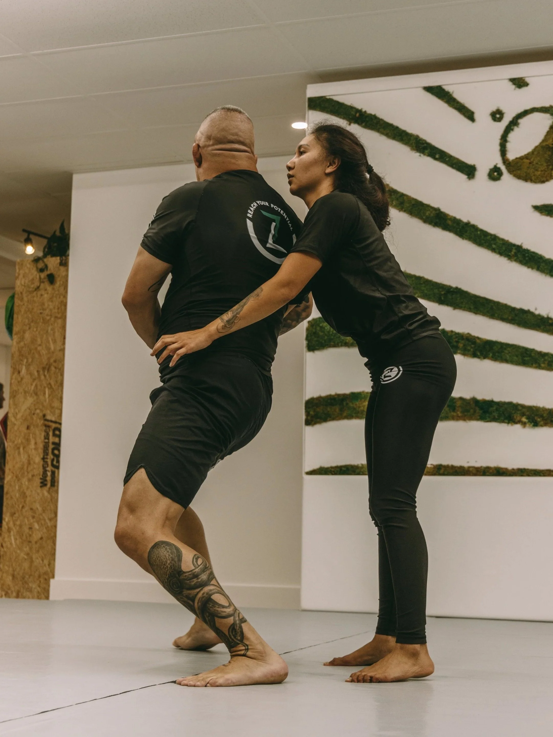 Instructor coaching a woman on a safe, controlled escape from a body-hold during a women’s self-defense class at Houzn Jiu Jitsu Academy in Mount Pleasant, SC.