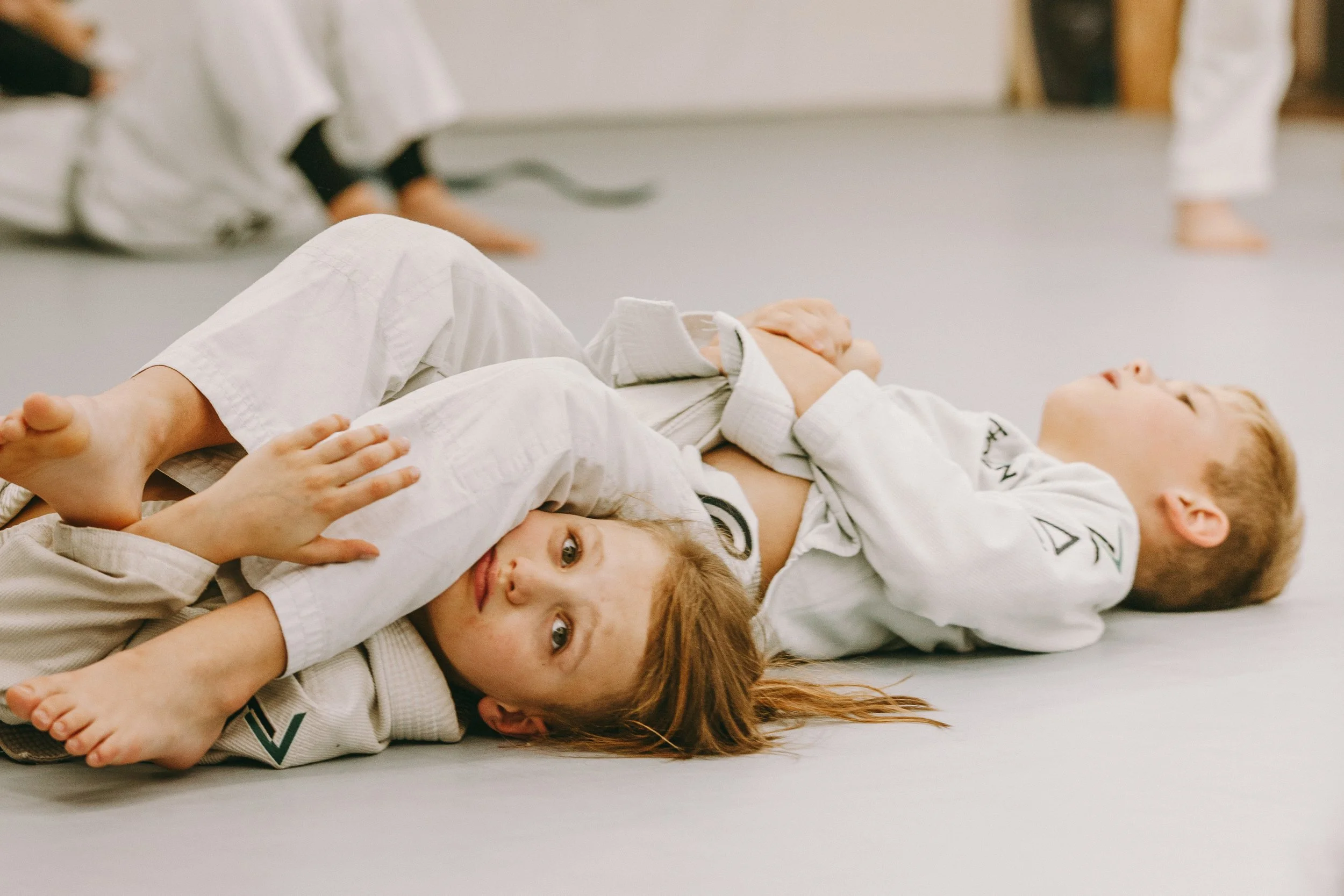 Two kids practice controlled partner drilling in kids jiu jitsu at Houzn Jiu Jitsu Academy in Mount Pleasant, SC.