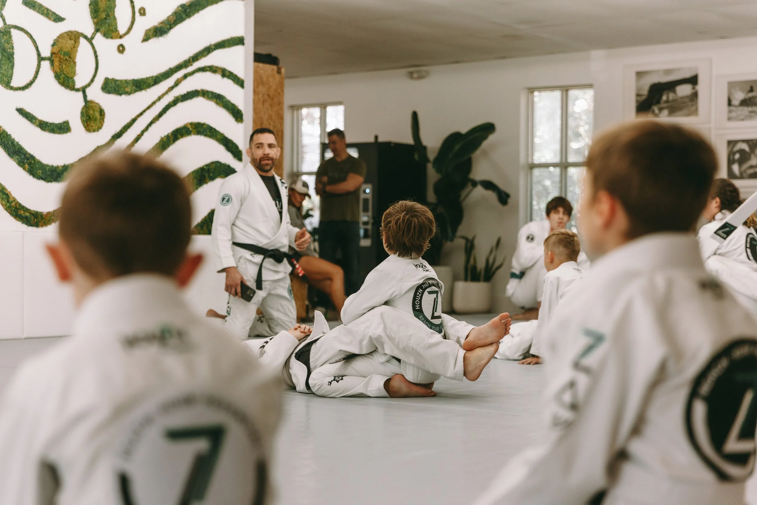 Kids Brazilian jiu-jitsu class at Houzn Jiu Jitsu Academy in Mount Pleasant, SC, with an instructor coaching students on the mats.