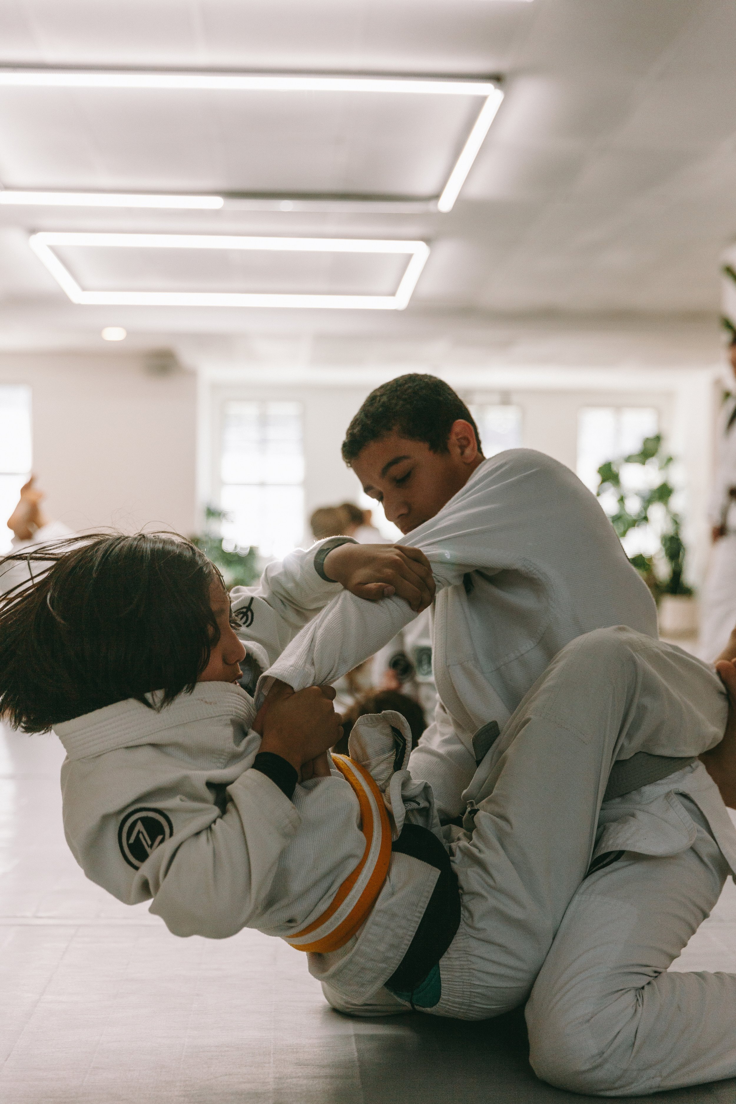 Two kids grapple during a Brazilian jiu-jitsu drill at Houzn Jiu Jitsu Academy in Mount Pleasant, SC.