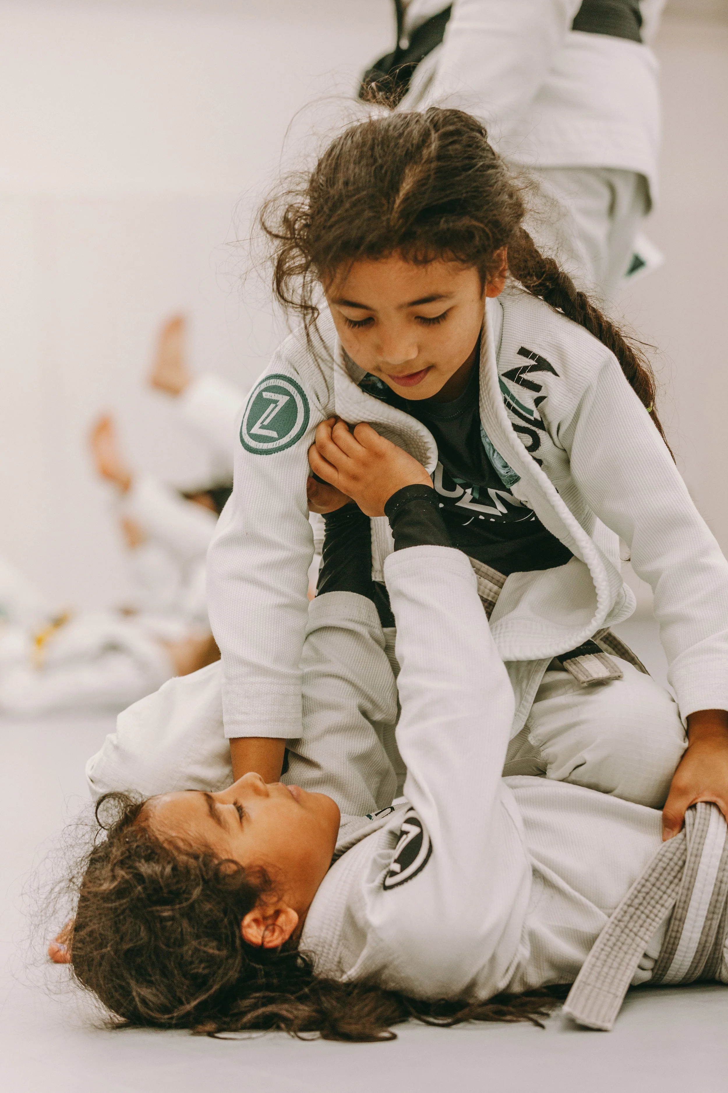 Kids practicing Brazilian jiu jitsu mount control and posture during training at Houzn Jiu Jitsu Academy.