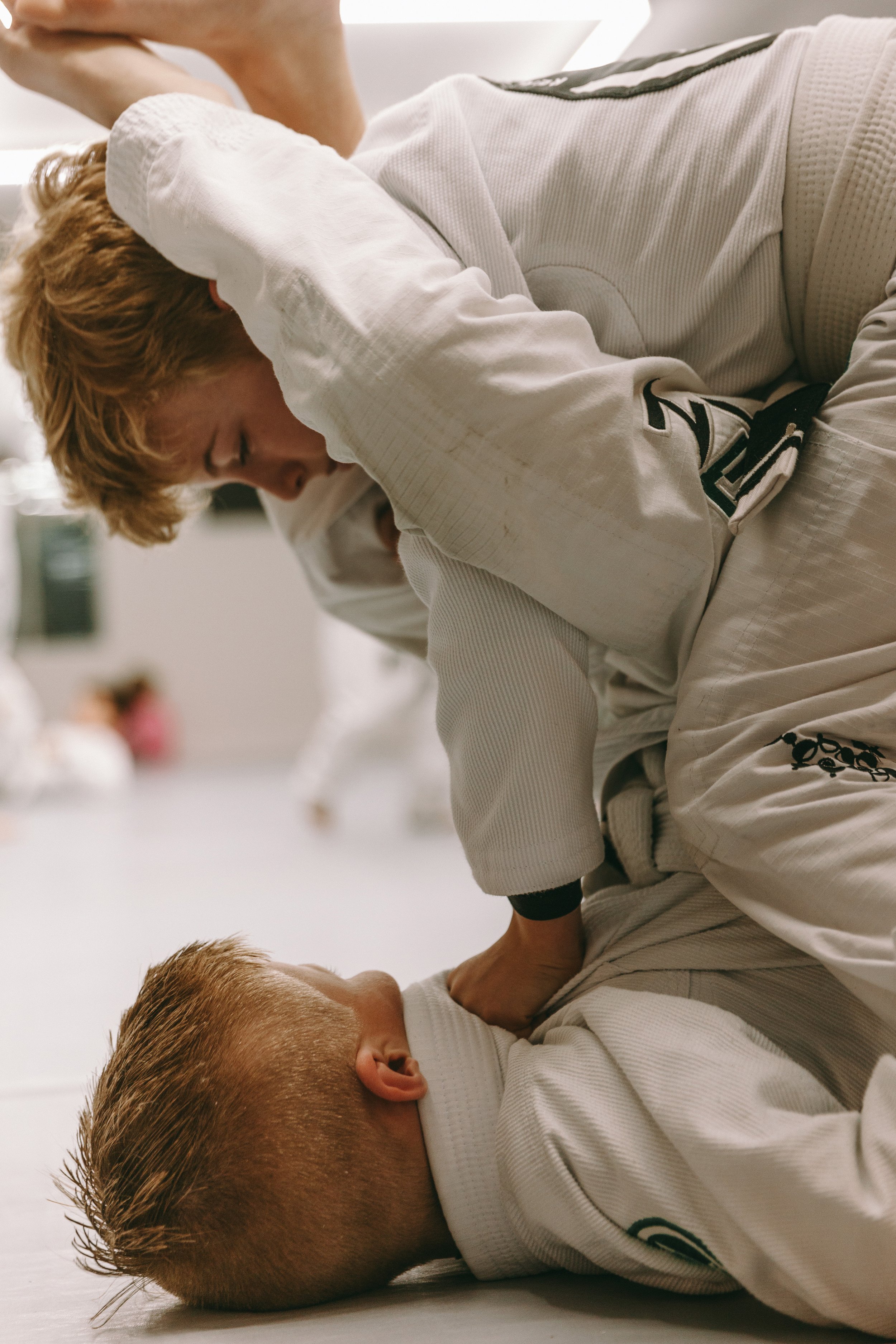 Kids Brazilian jiu jitsu students at Houzn Jiu Jitsu Academy practicing mount control and pressure in white gis