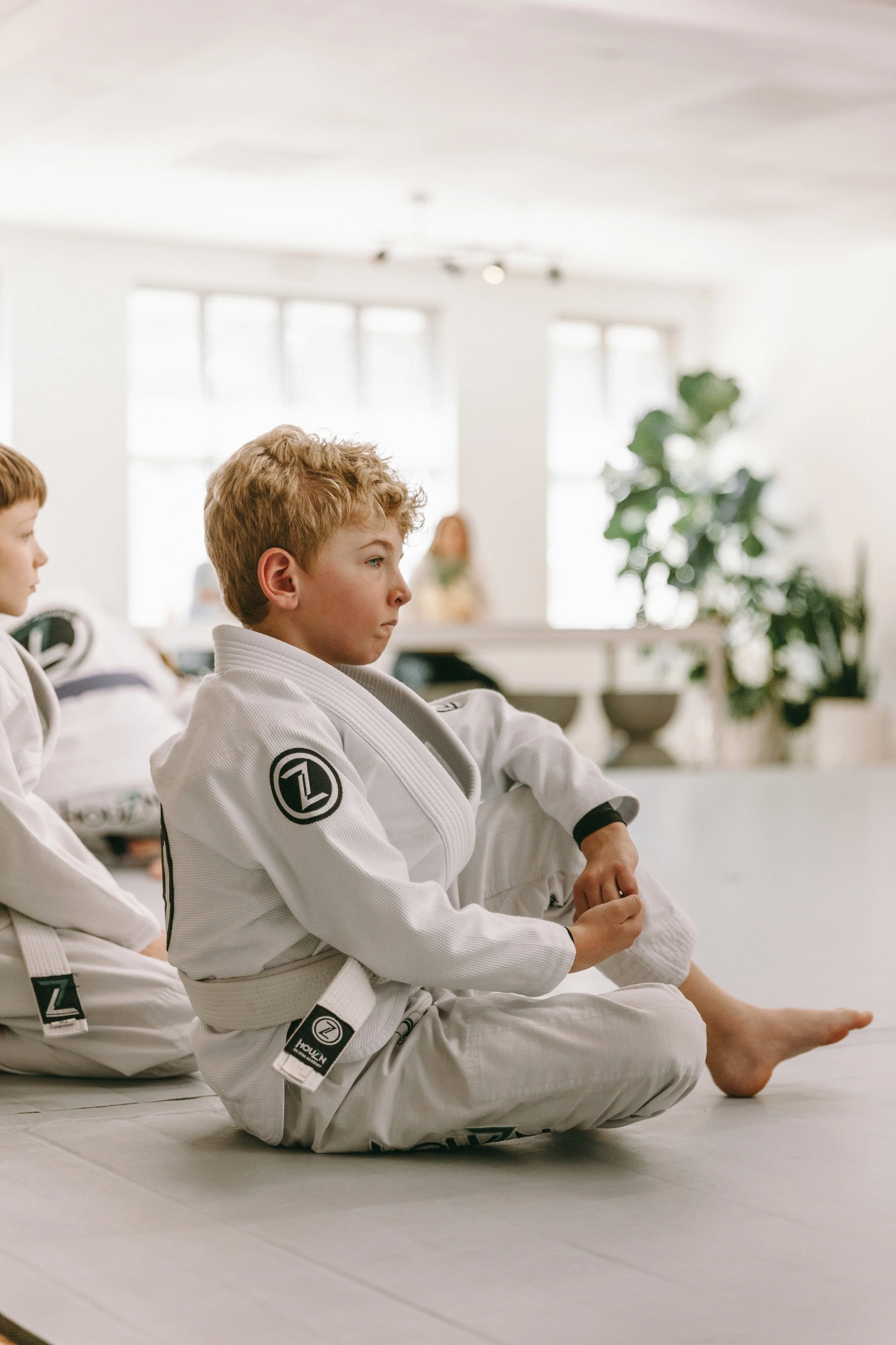 Youth student in a white gi listening during class at Houzn Jiu Jitsu Academy in Mount Pleasant, SC.