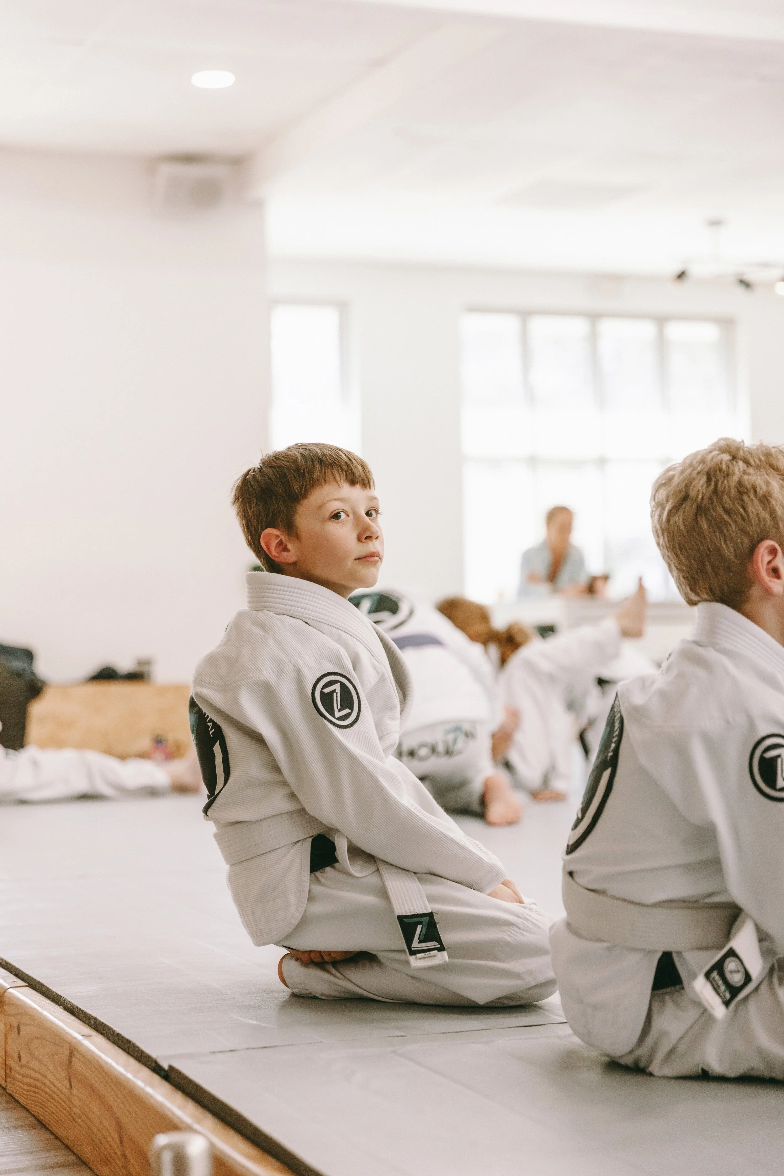 `Kids sitting on the mats during a Houzn Jiu Jitsu Academy children’s jiu jitsu class in Mount Pleasant, SC.`
