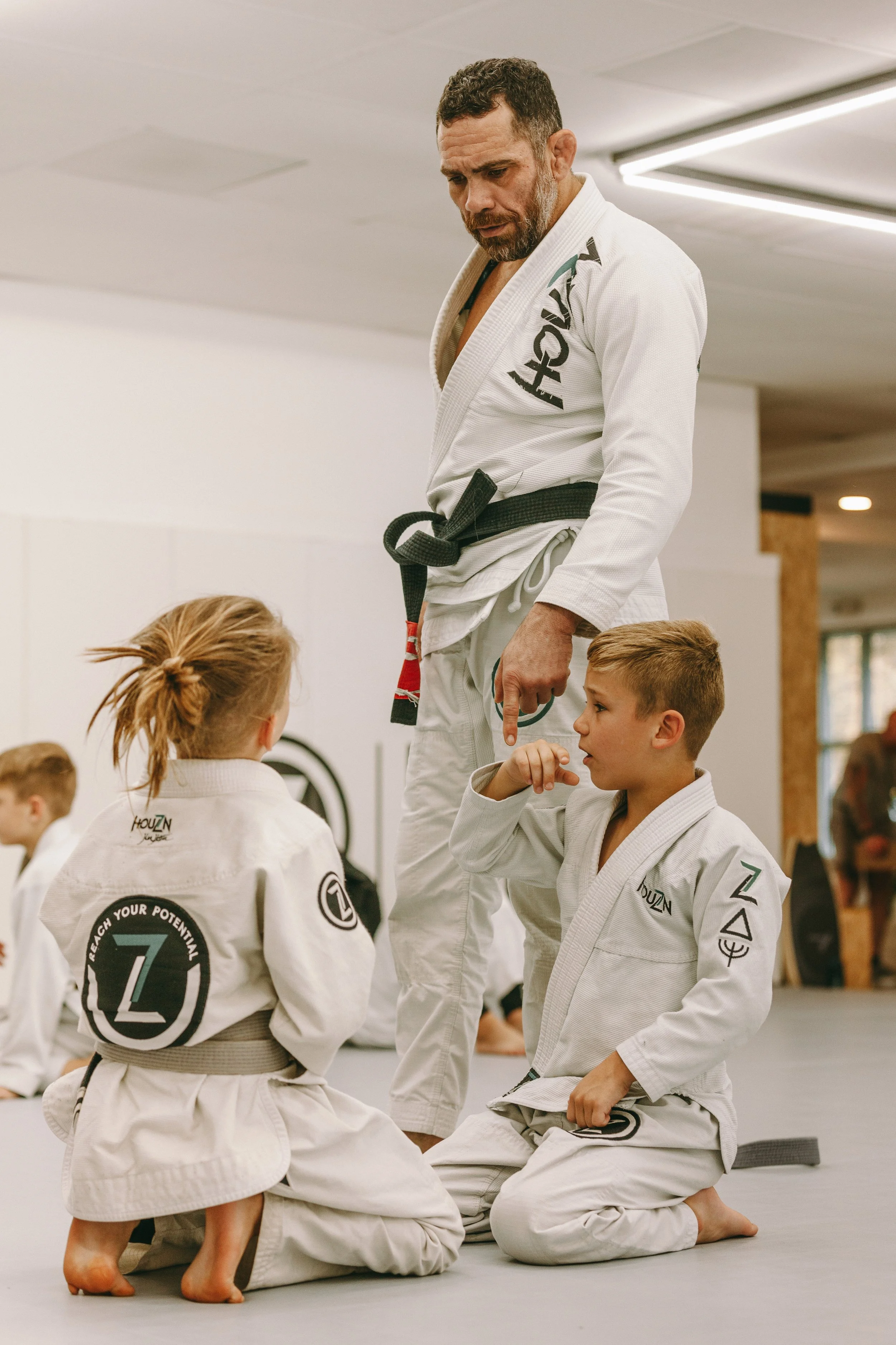 BJJ coach giving instruction to children during a kids jiu jitsu class at Houzn Jiu Jitsu Academy.