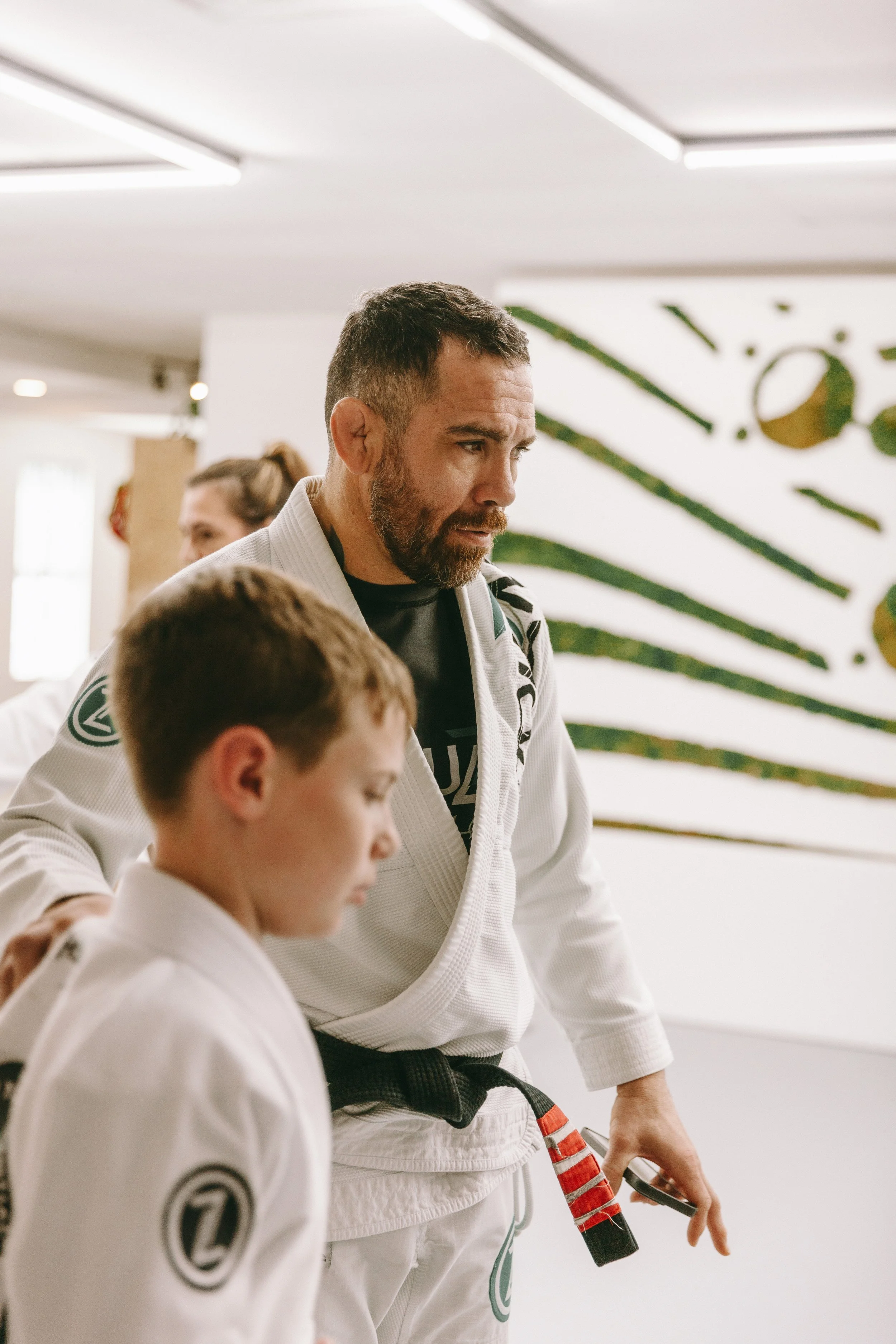 Kids jiu jitsu coach helps a student during class at Houzn Jiu Jitsu Academy in Mount Pleasant, SC.