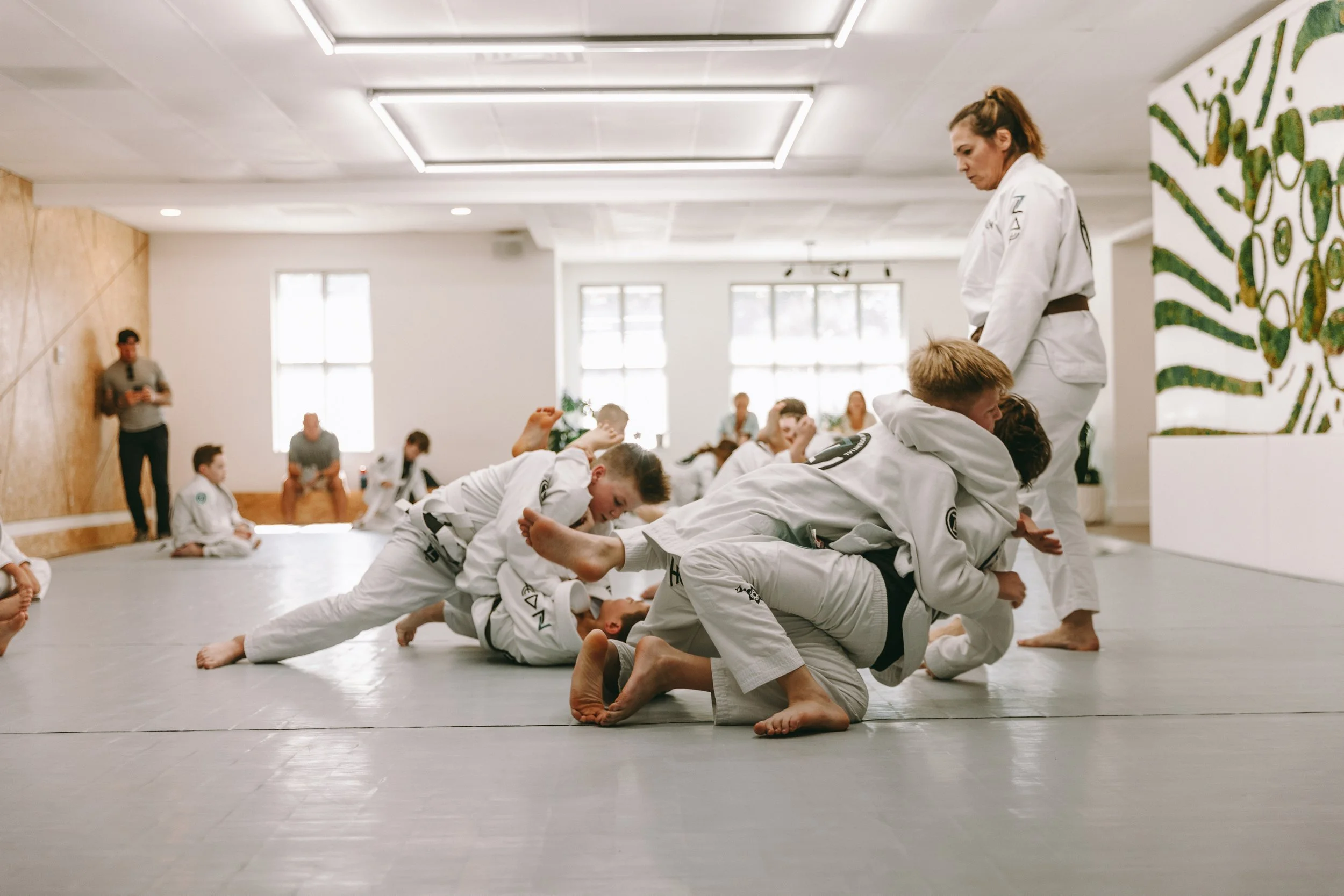 `Kids doing controlled grappling during a Brazilian jiu jitsu class at Houzn Jiu Jitsu Academy in Mount Pleasant, SC.`