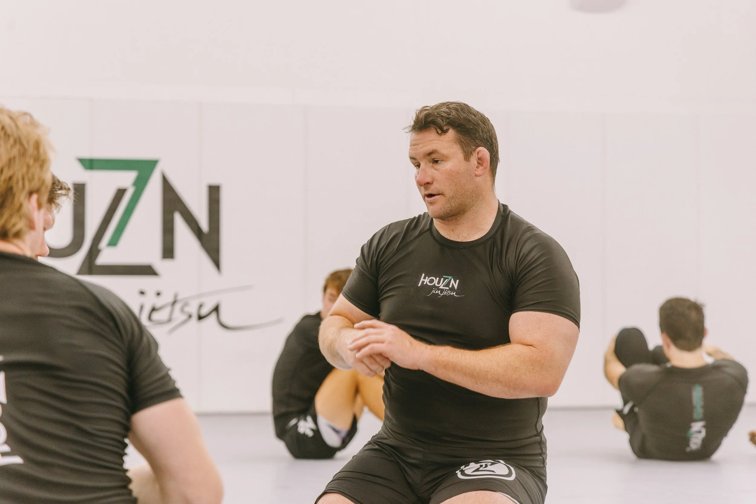 Van Barnhill explaining a Jiu Jitsu technique to his teammates at Houzn.