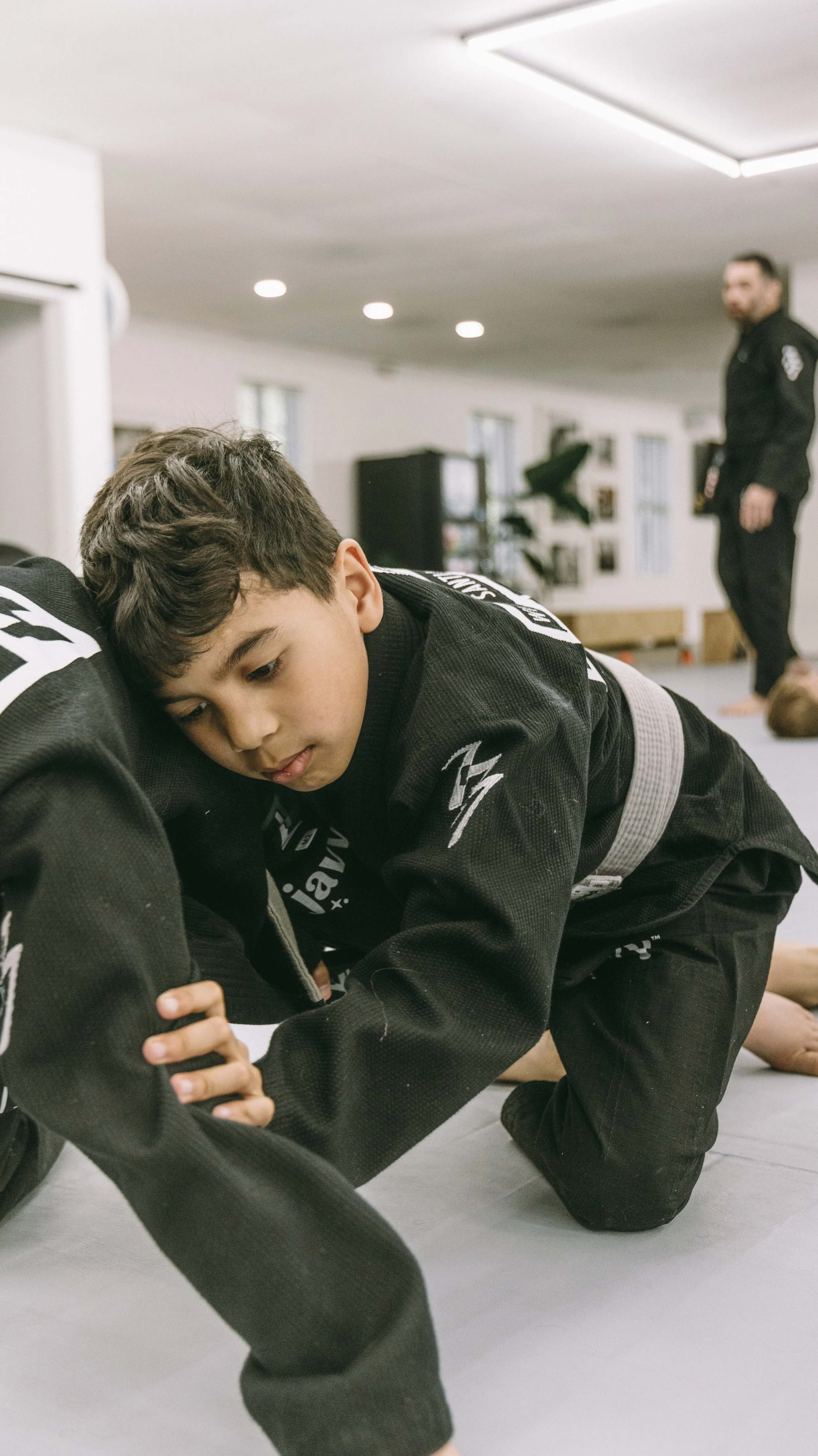 Child works on groundwork technique in kids jiu jitsu at Houzn Jiu Jitsu Academy in Mount Pleasant, SC.