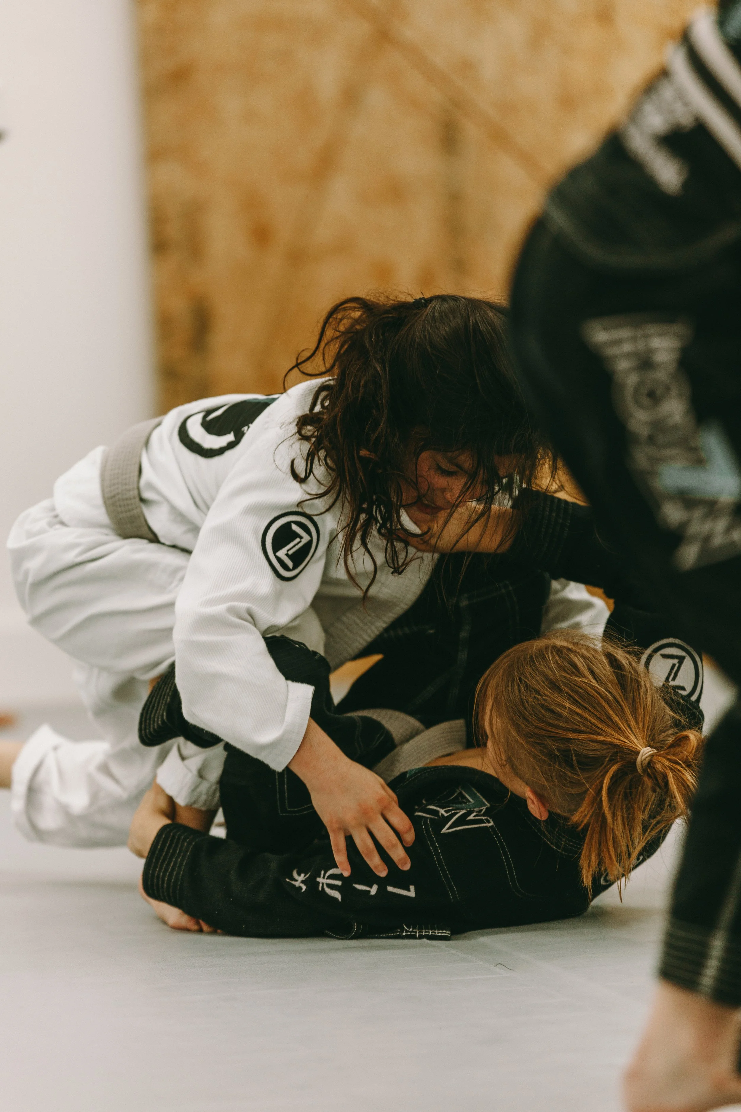 Child practices top control from mount during kids Brazilian jiu jitsu at Houzn Jiu Jitsu Academy in Mount Pleasant, SC.