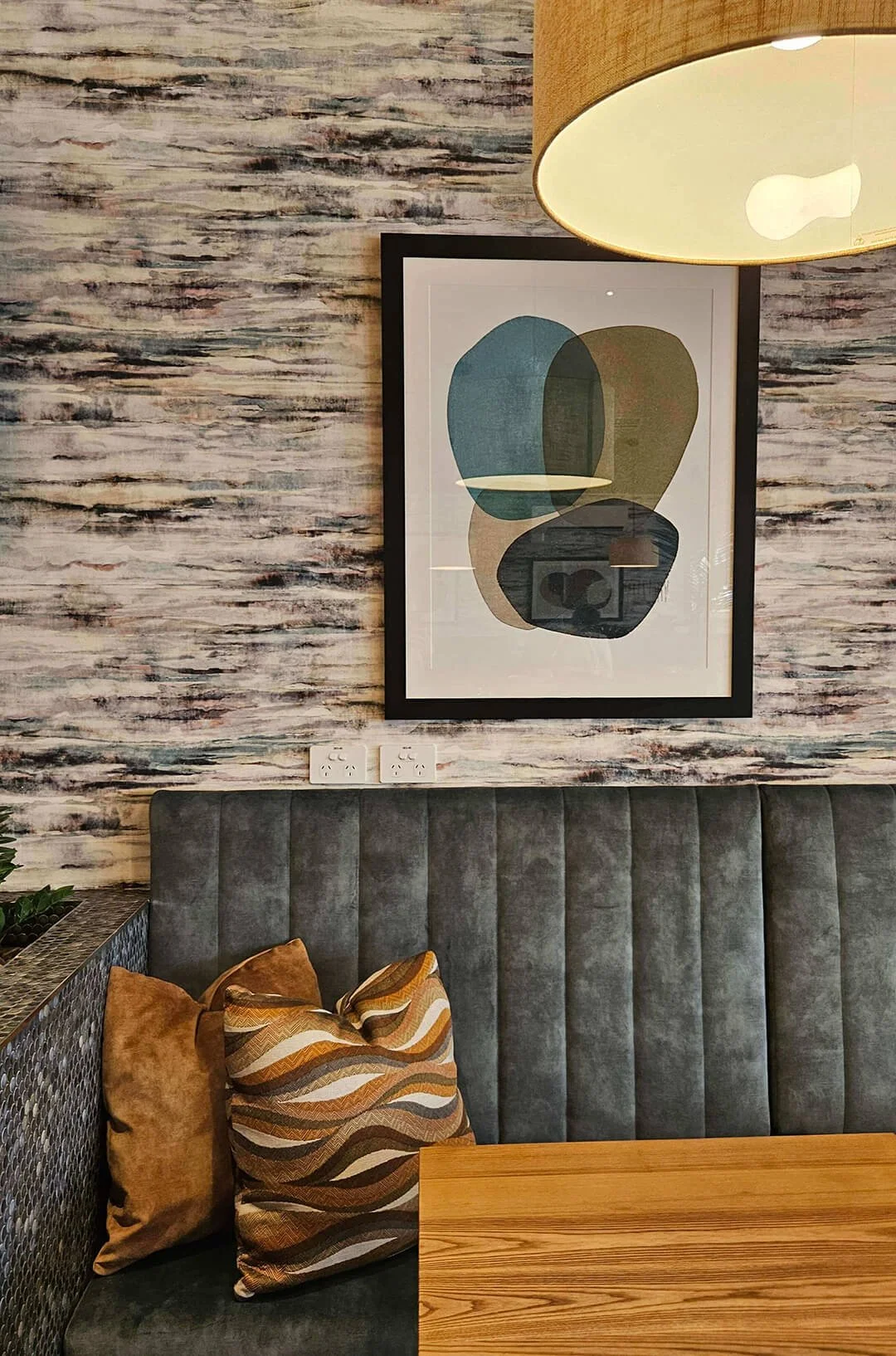Textured wall finish paired with curated artwork, creating a calm and grounded interior palette.