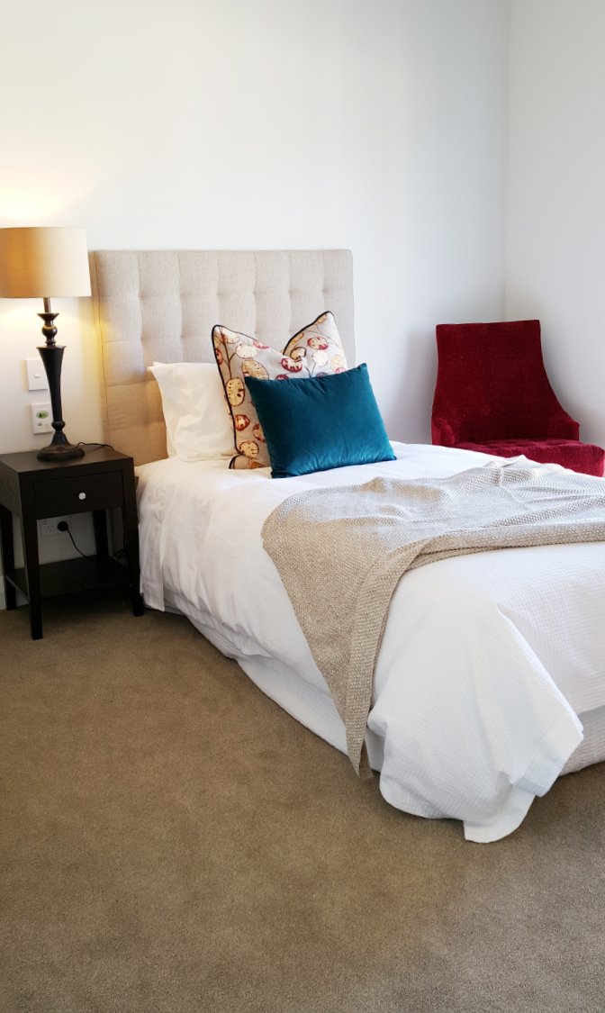 Chic healthcare bedroom interior with statement cream headboard, New Zealand.