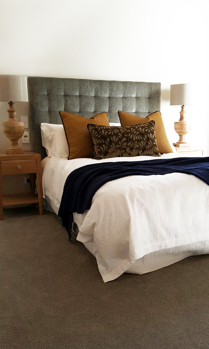 Chic healthcare bedroom interior with statement sage headboard, New Zealand.