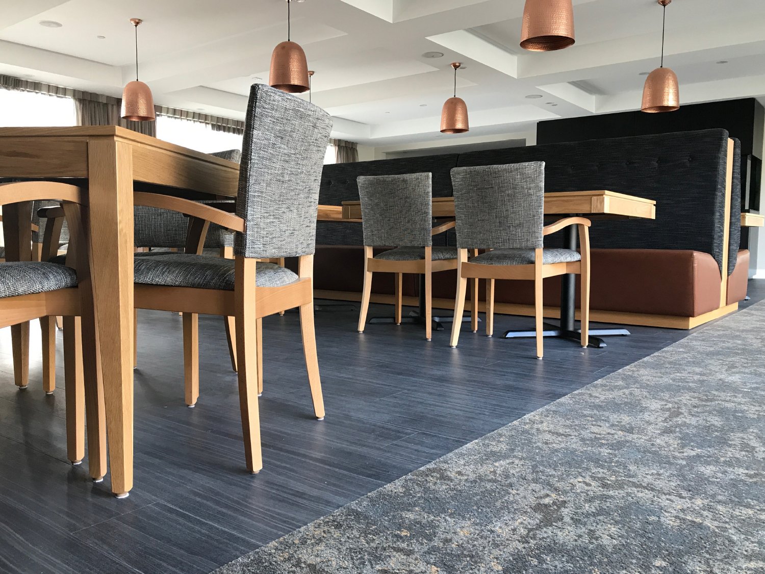 Chic healthcare dining room interior with statement bronze hanging lights, New Zealand.