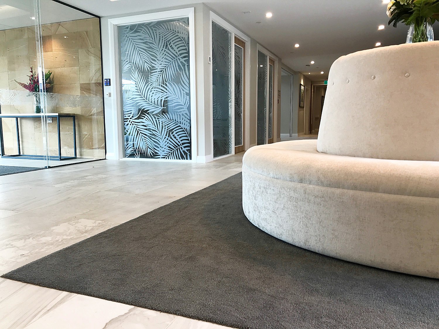 Chic healthcare interior design of reception with pattern frosted glass graphics of ferns, New Zealand.