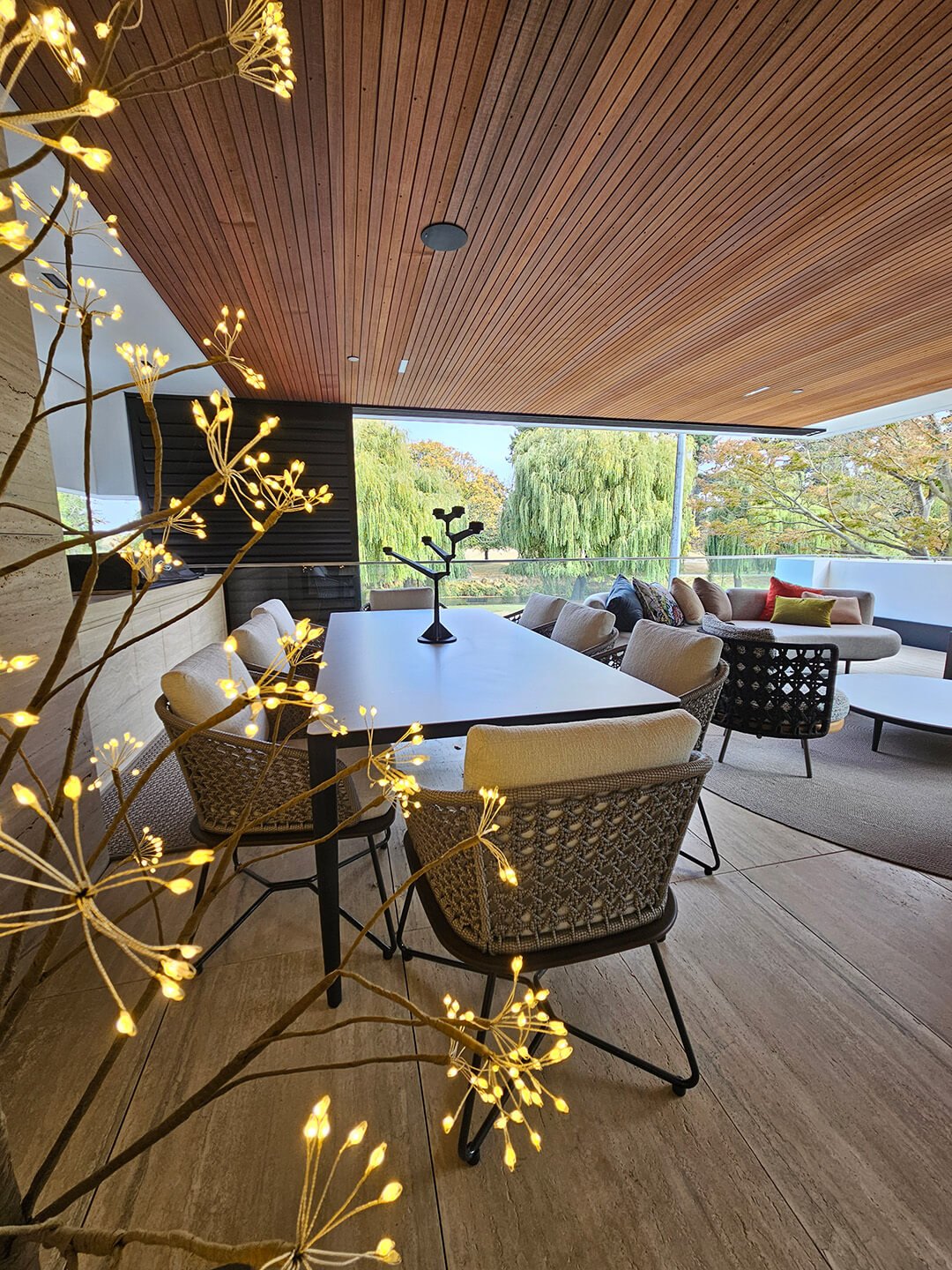 Elegant Dining Area with Modern Light Fixtures: A dining area featuring modern light fixtures, a round table, and contemporary chairs, set against a backdrop of floor-to-ceiling windows that flood the space with natural light.