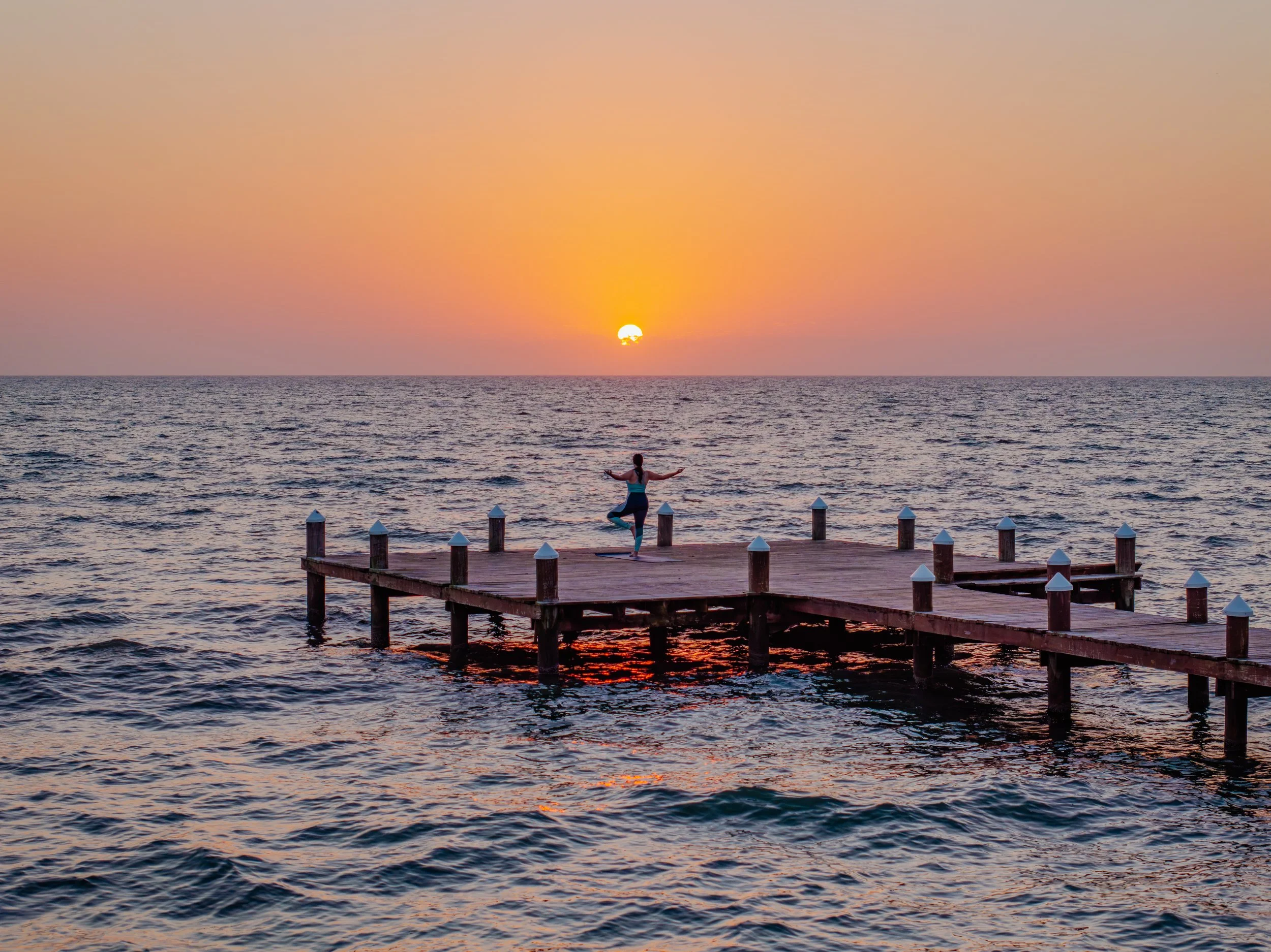 Guided through the river cave, two women on tubes are awestruck as their lamps illuminate a giant stalactite chandelier above them.