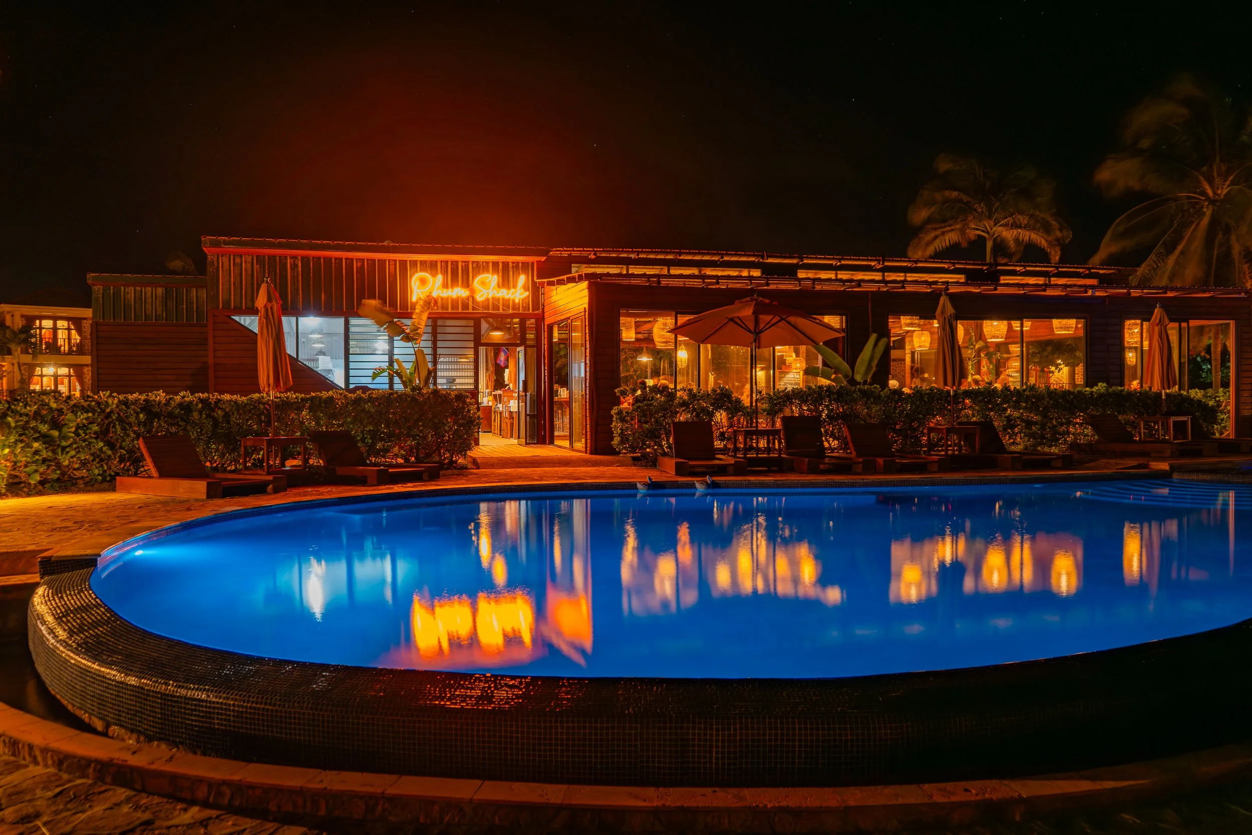 Fog drifts through the valleys of Caves Branch at dawn, painted in soft purple and orange light, contrasting with the vibrant green jungle hills.