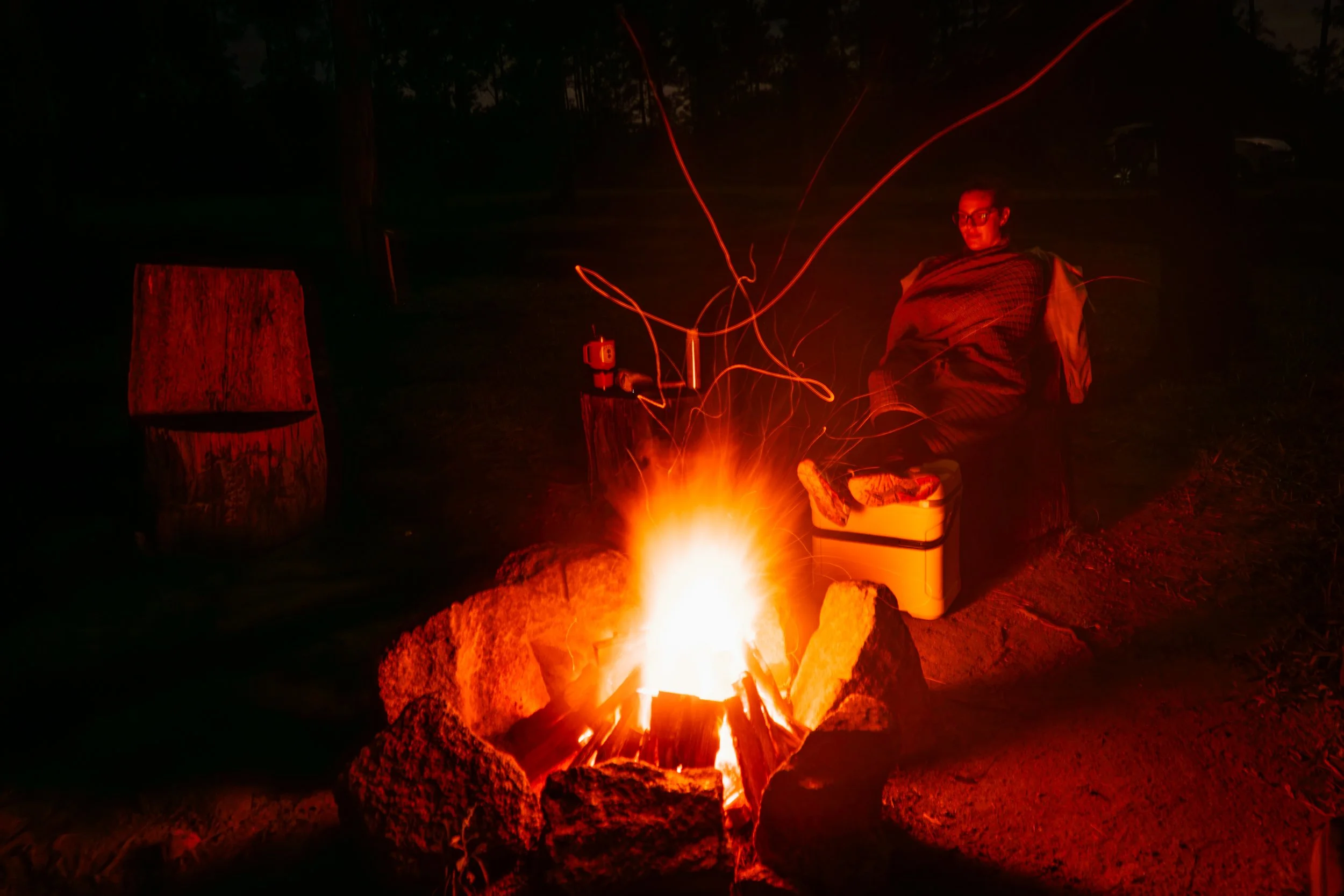 Fog drifts through the valleys of Caves Branch at dawn, painted in soft purple and orange light, contrasting with the vibrant green jungle hills.
