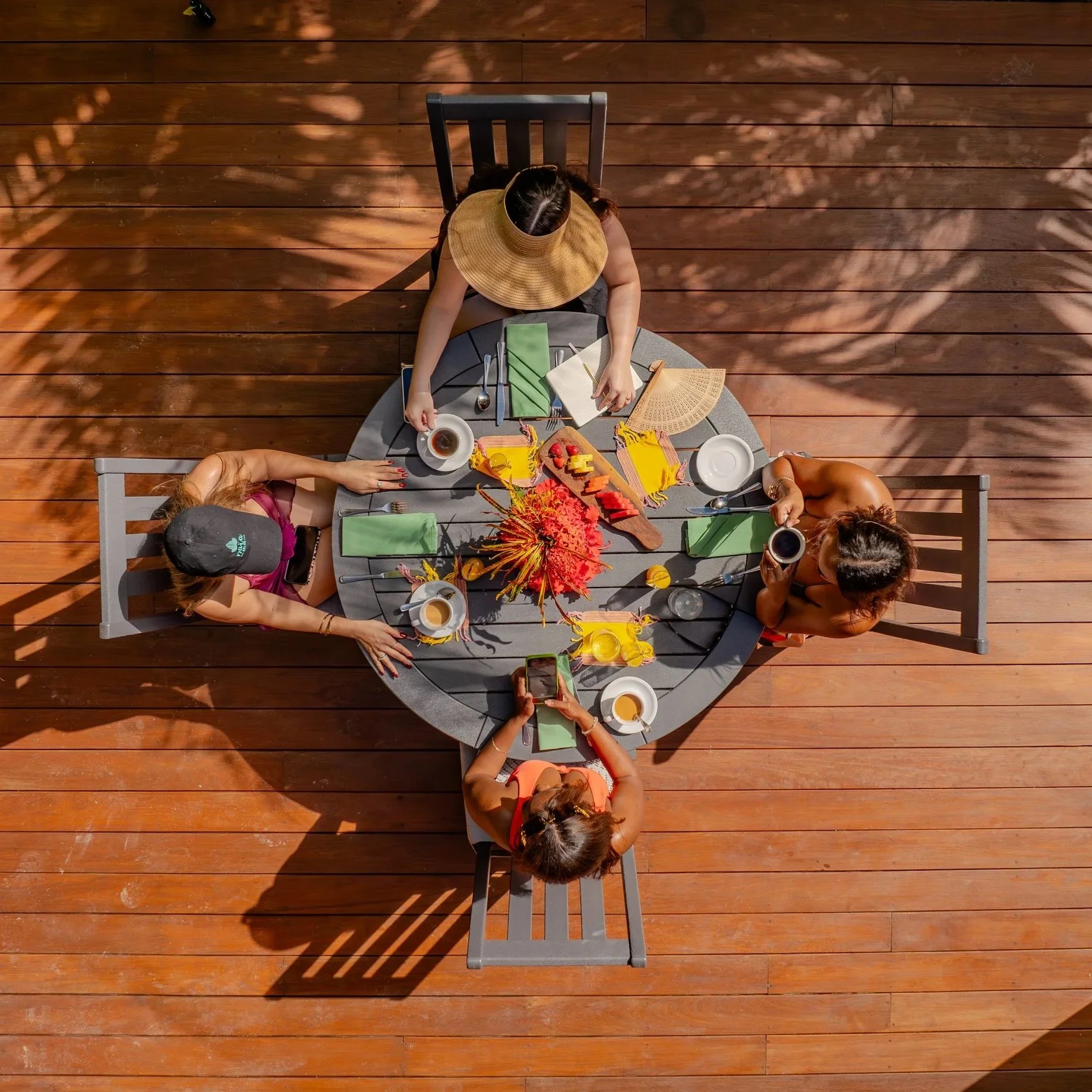A top-down drone view of four friends enjoying a private lunch on the veranda of a luxury Spa Villa at Naia Resort and Spa.