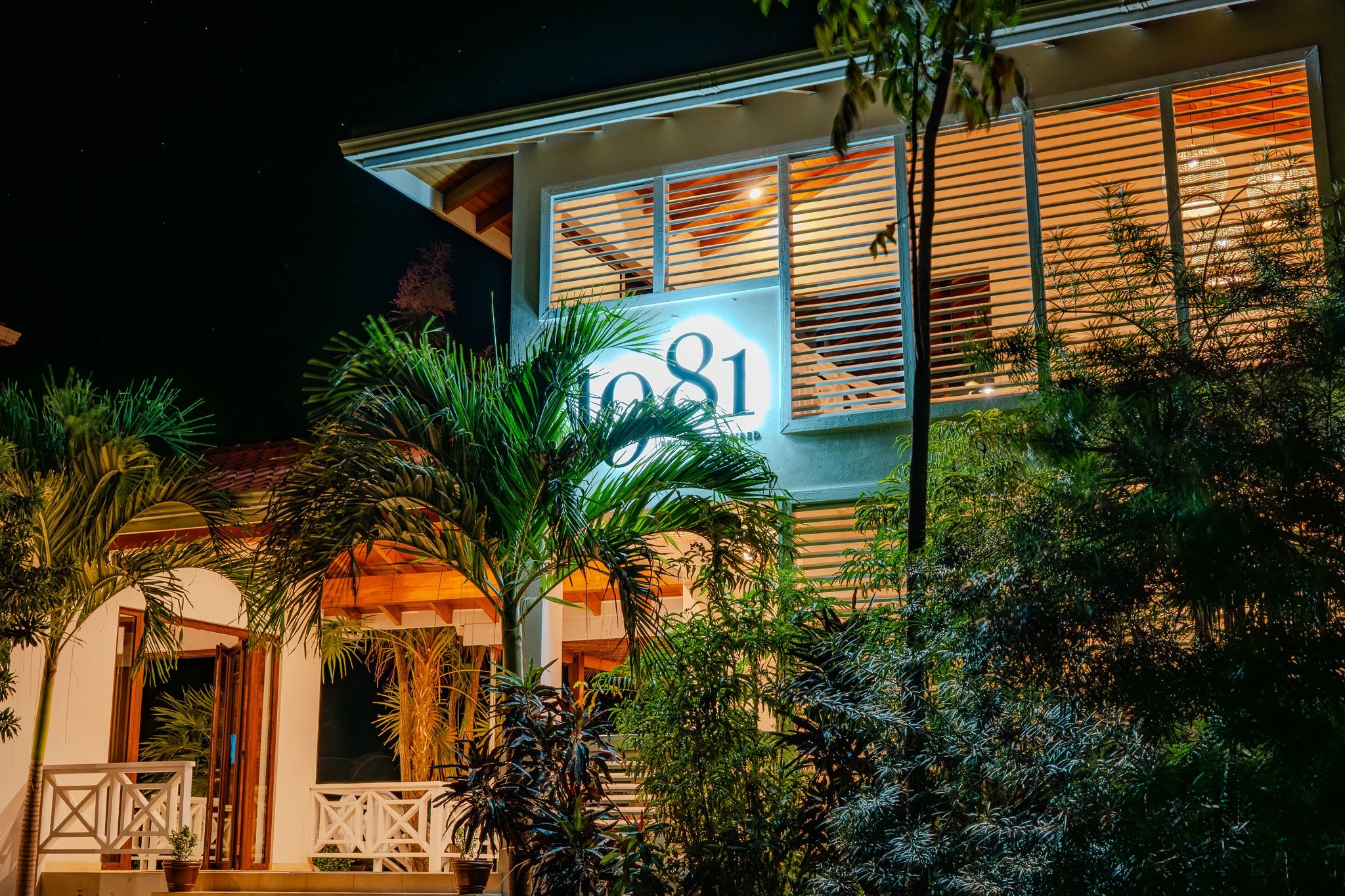 The illuminated 1981 Restaurant sign at Naia Resort and Spa, glowing against the night sky to welcome dinner guests.