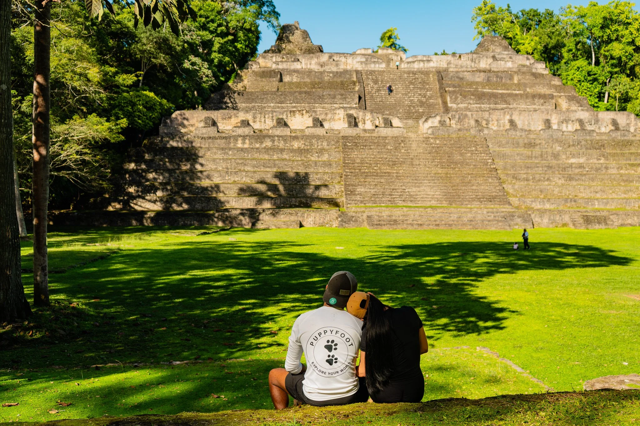 In a hidden corner of the cave, a guide and explorer uncover an ancient Maya shoe pot, a glimpse into history amidst the darkness.