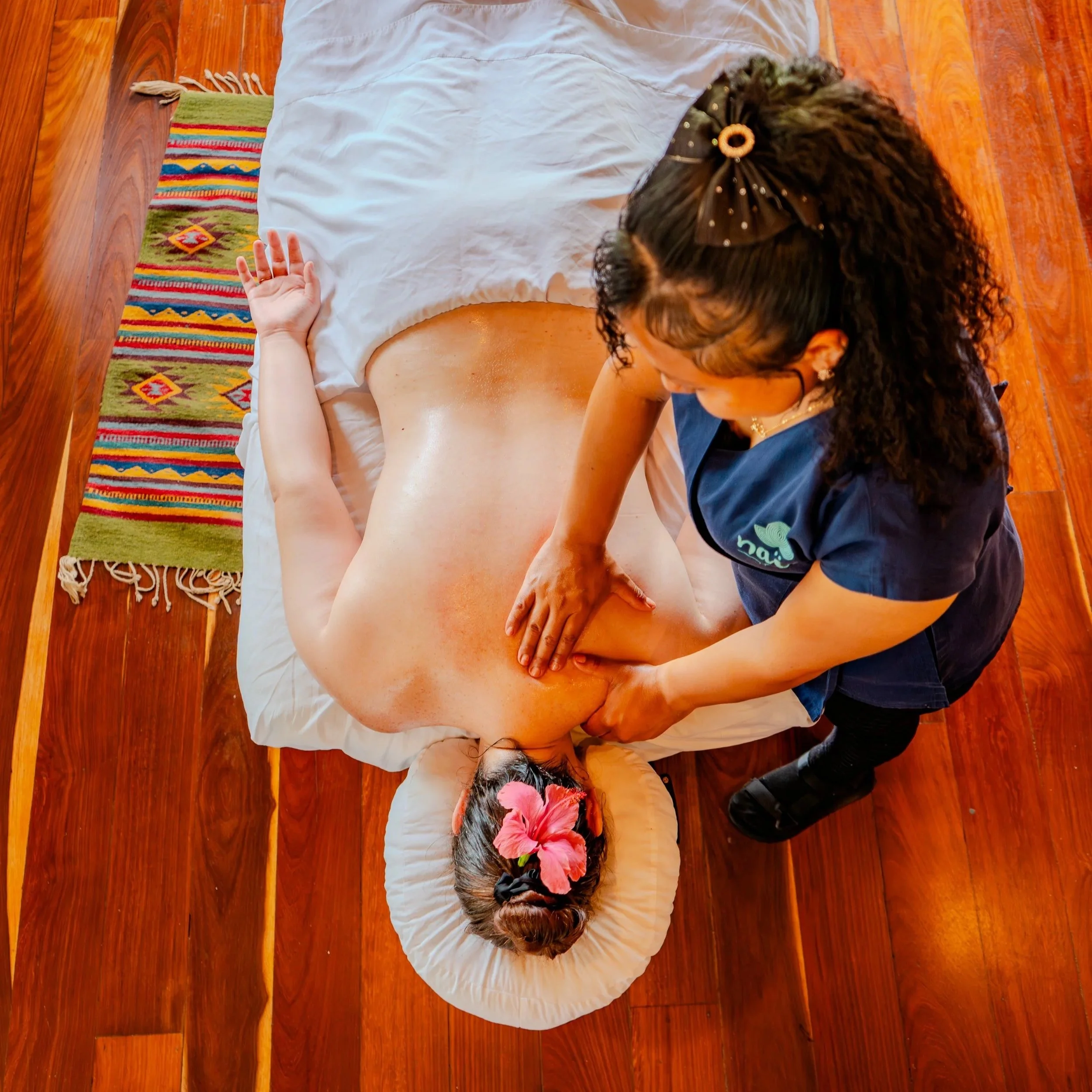 Overhead view of a guest receiving a relaxing massage from a professional therapist at the award-winning Naia Resort and Spa.