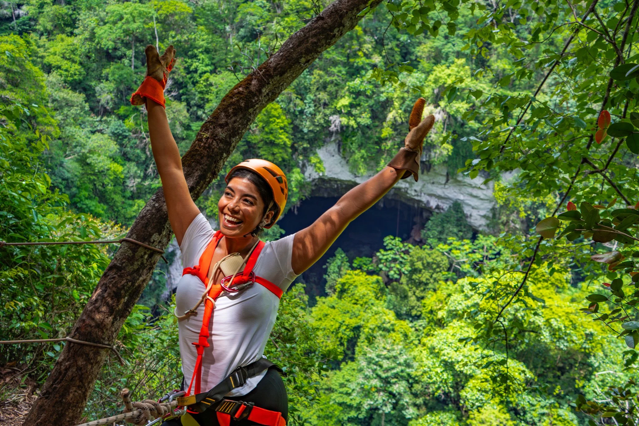 Filled with anticipation, a woman braces herself at the edge of the Black Hole Drop Sinkhole, ready for the descent.