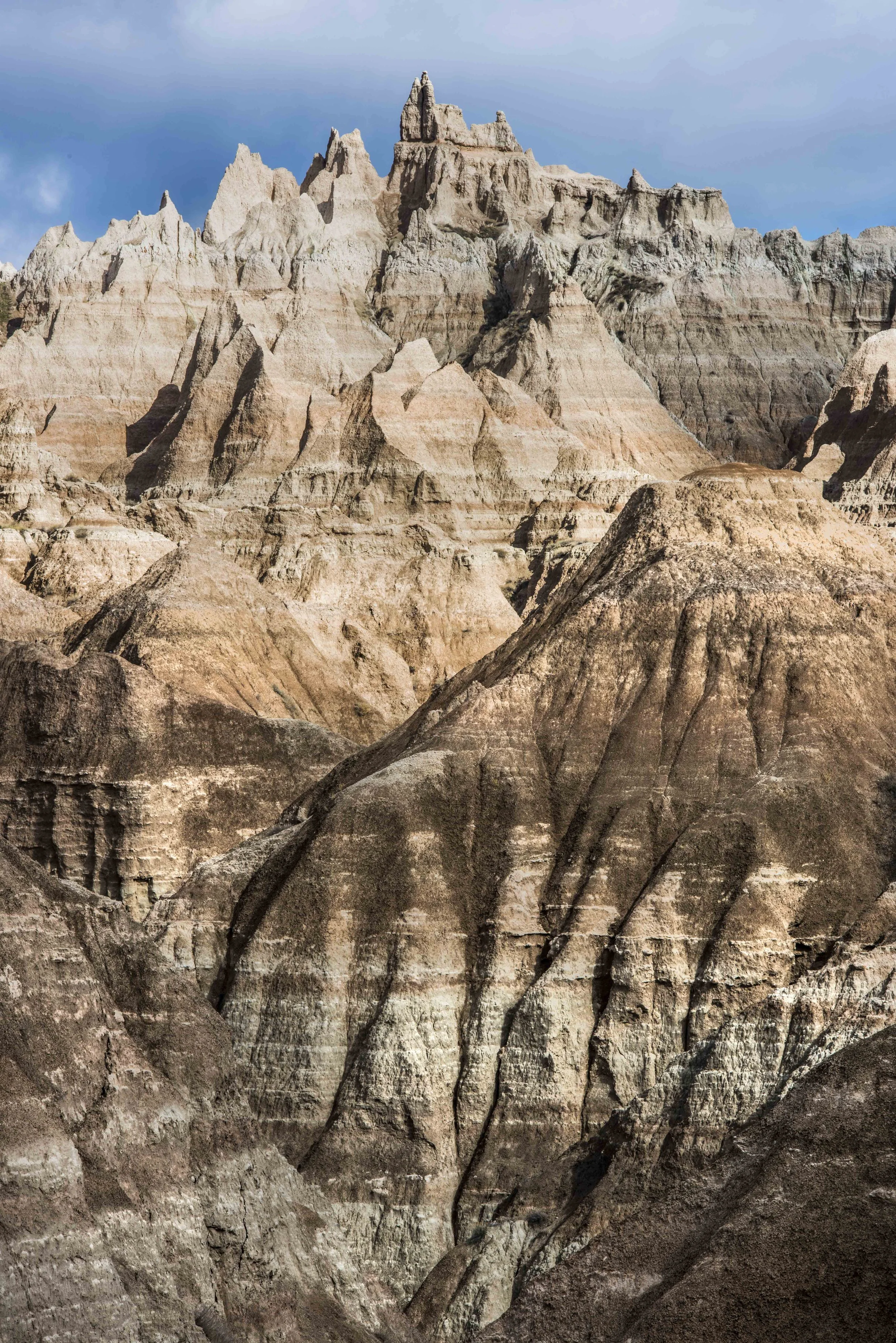 Eroded rock formations in a desert landscape with layered sedimentary patterns.