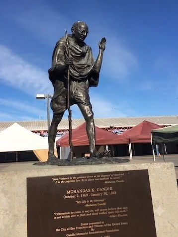 Bronze statue of Mahatma Gandhi on a concrete pedestal with a commemorative plaque in San Francisco.