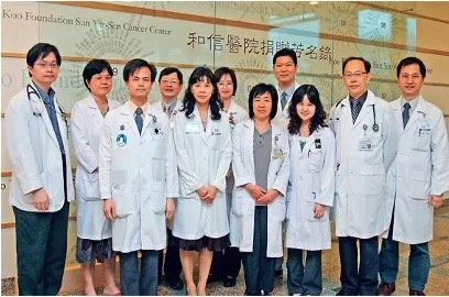 Group of healthcare professionals in white lab coats standing in front of a hospital entrance