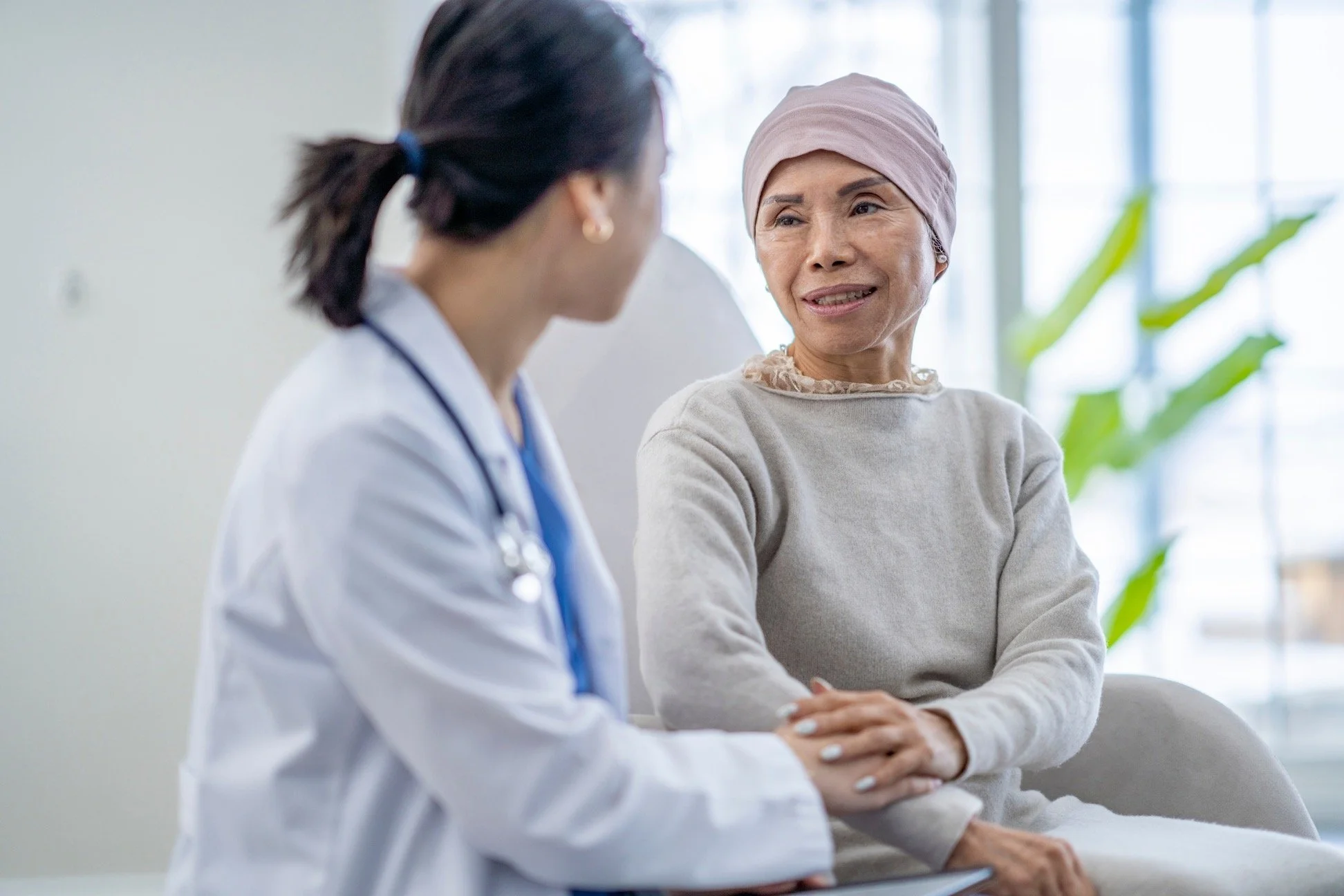 A doctor speaking with an elderly woman in a medical office.