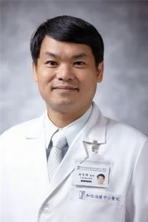 Portrait of a male doctor wearing a white coat and tie, with an ID badge