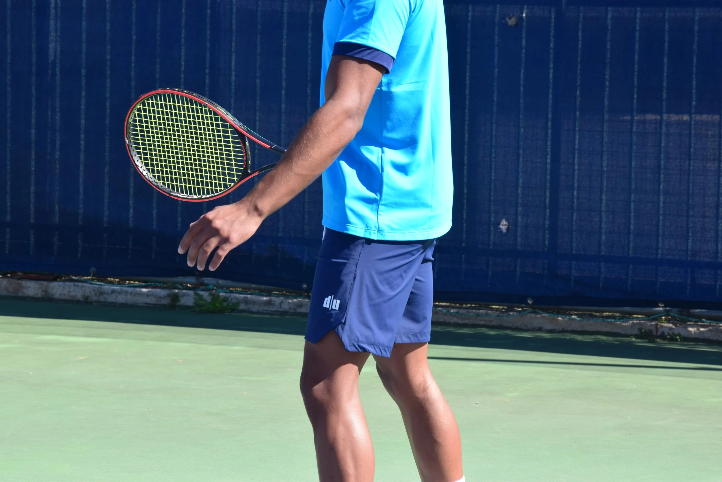 Giocatore di tennis in tenuta blu sulla racchetta sul campo da tennis.