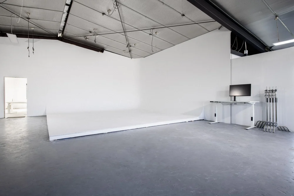 Studio 02 white shooting space with industrial ceiling and equipment.