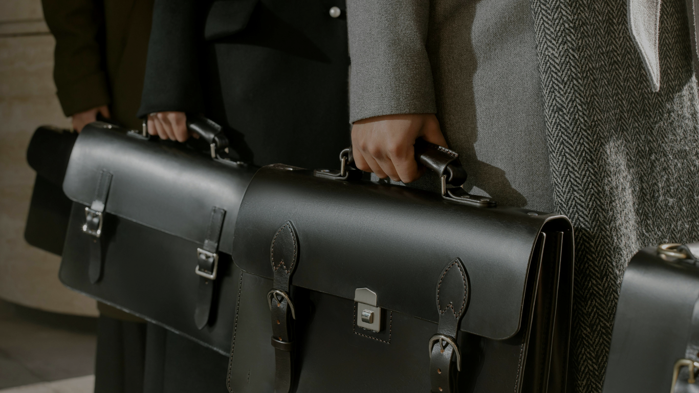Lawyers holding black leather briefcases, dressed in formal coats.