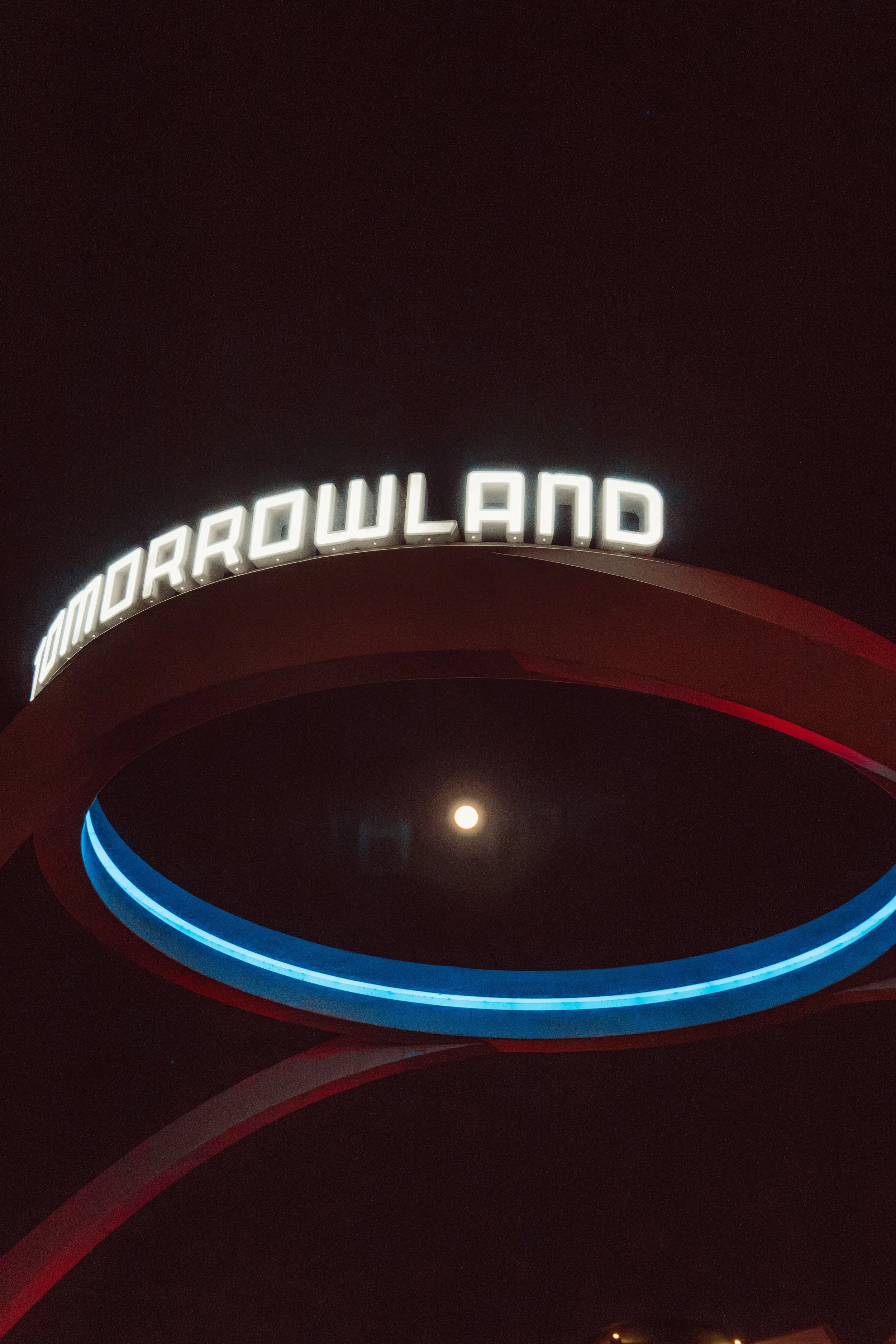 Nighttime view of the Galaxy's Edge sign at Disney's Hollywood Studios, with the moon visible in the sky.