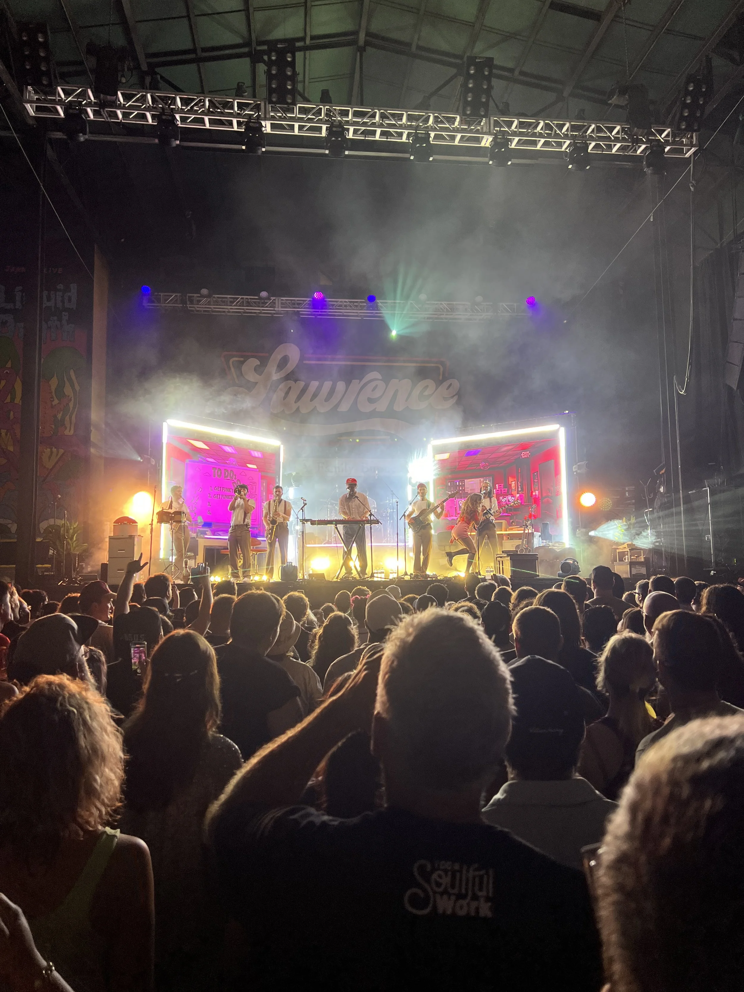 Live concert at a music festival with a band performing on stage and an audience watching
