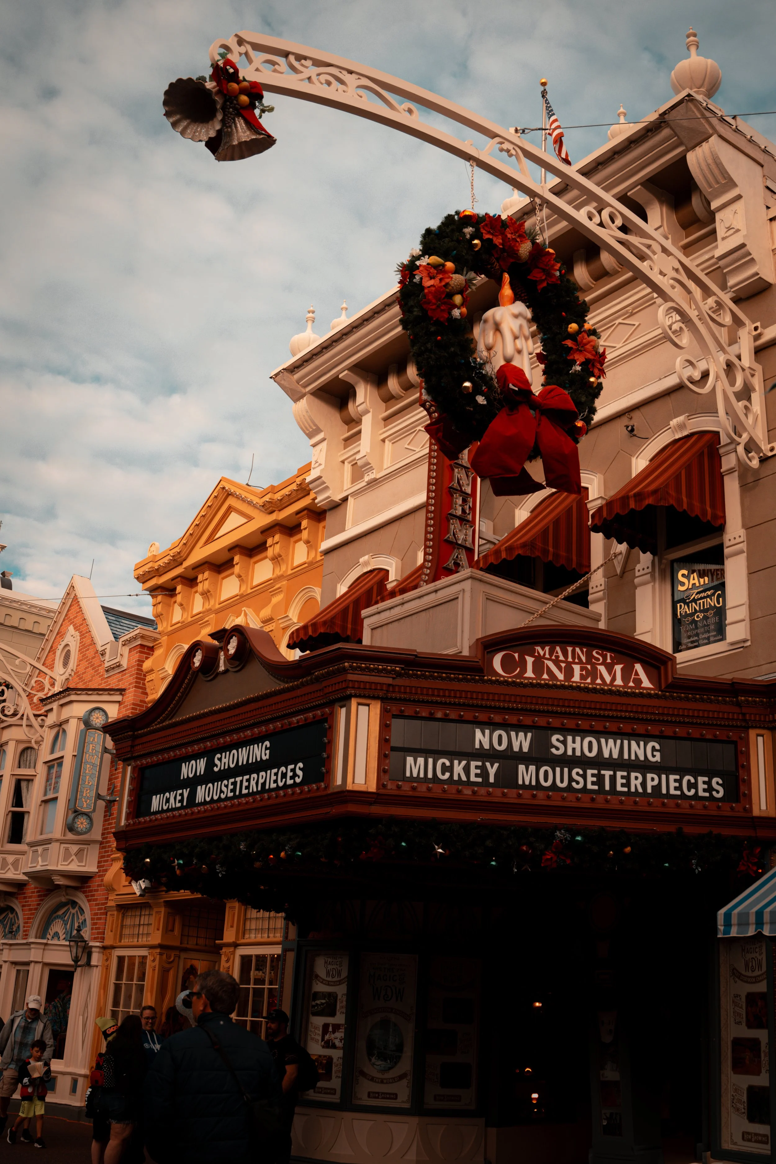 The Disney Main Street Cinema marquee advertising Mickey Mouse masterpieces, with a decorative heart-shaped wreath and Christmas decorations on the building facade.