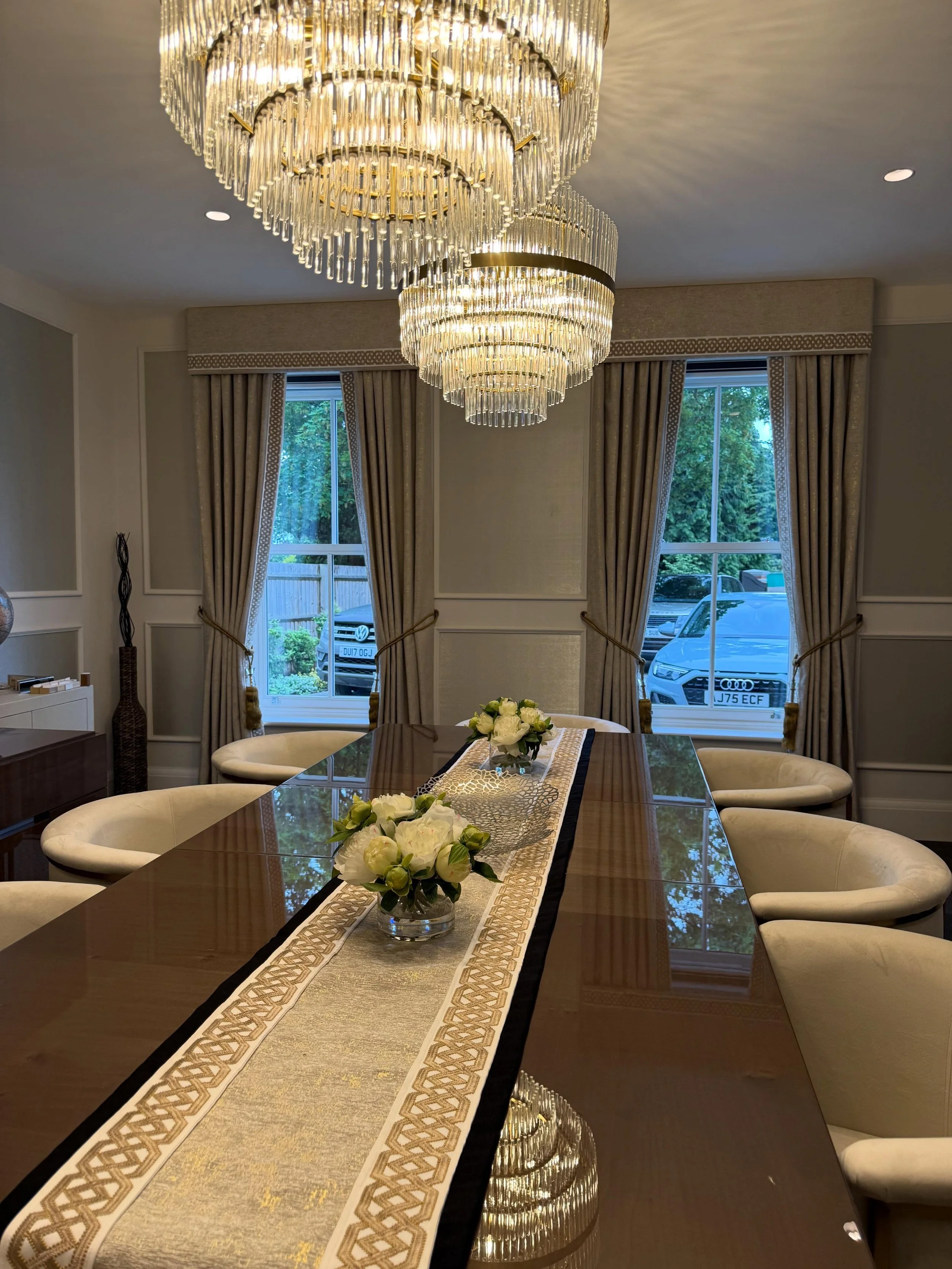 A beautifully coordinated dining room scheme featuring bespoke curtains, matching pelmets, and an elegant table runner, crafted in @clarke_clarke_interiors Lusso Shimmer Gold fabric. Finished with the refined detail of @jamesharefabric Cora Gold Tape