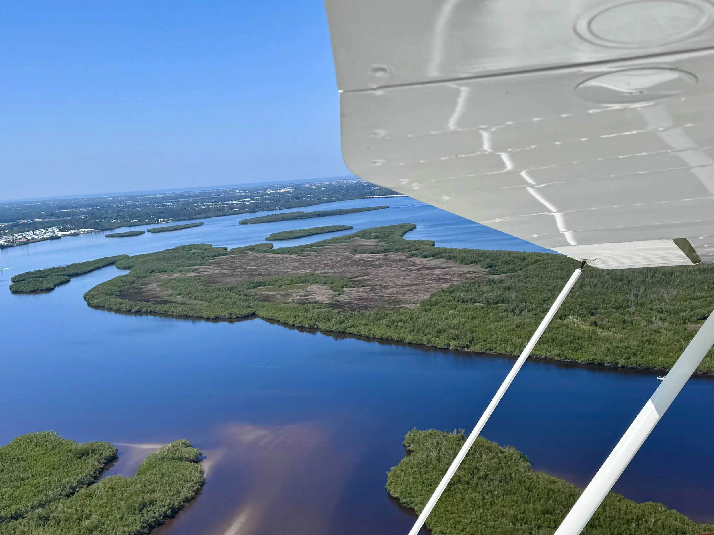 Aerial view of Peace River with green islands and land, seen from Gracie in daytime.