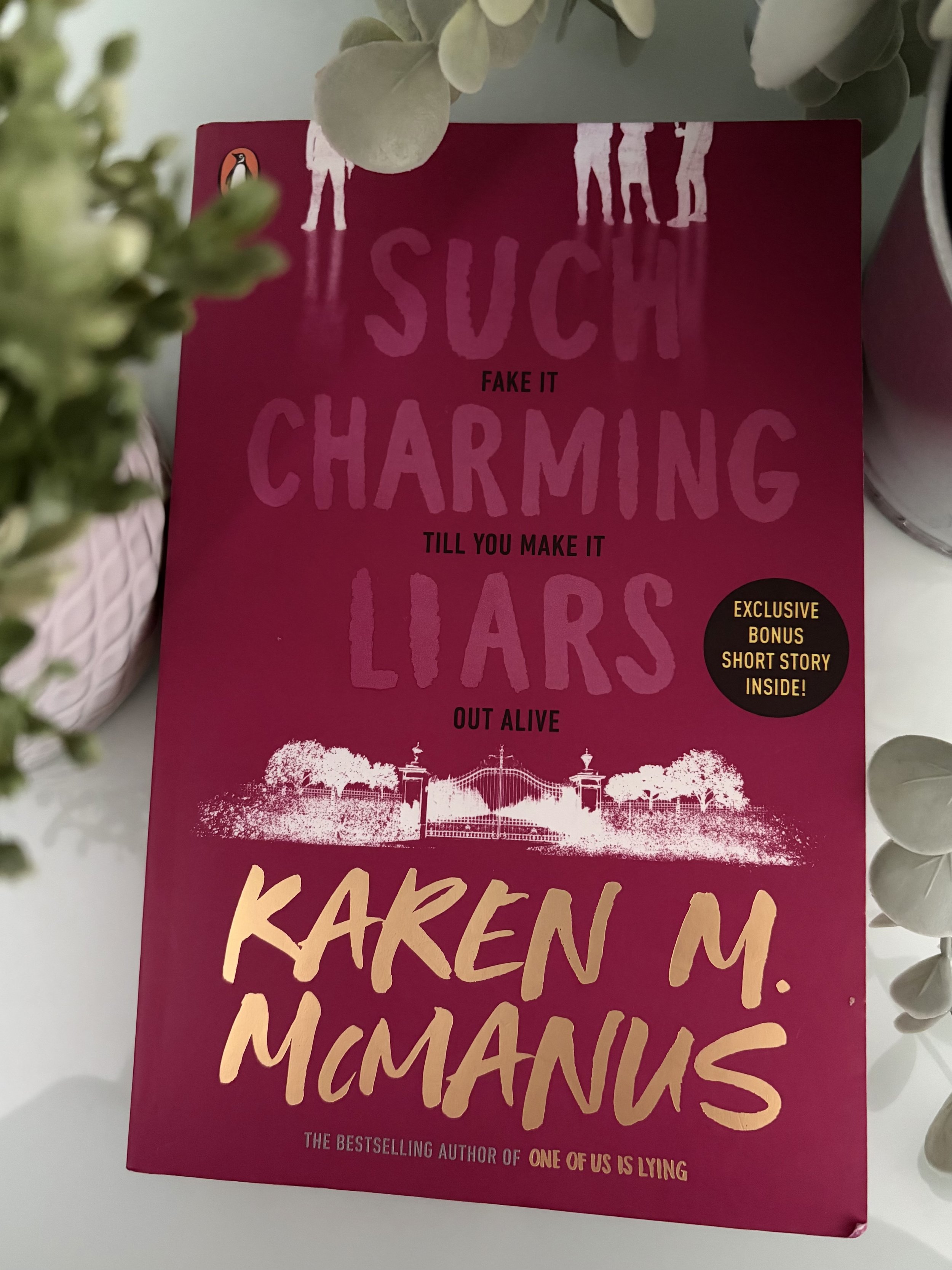 McManus's novel, Such Charming Liars surrounded by plants