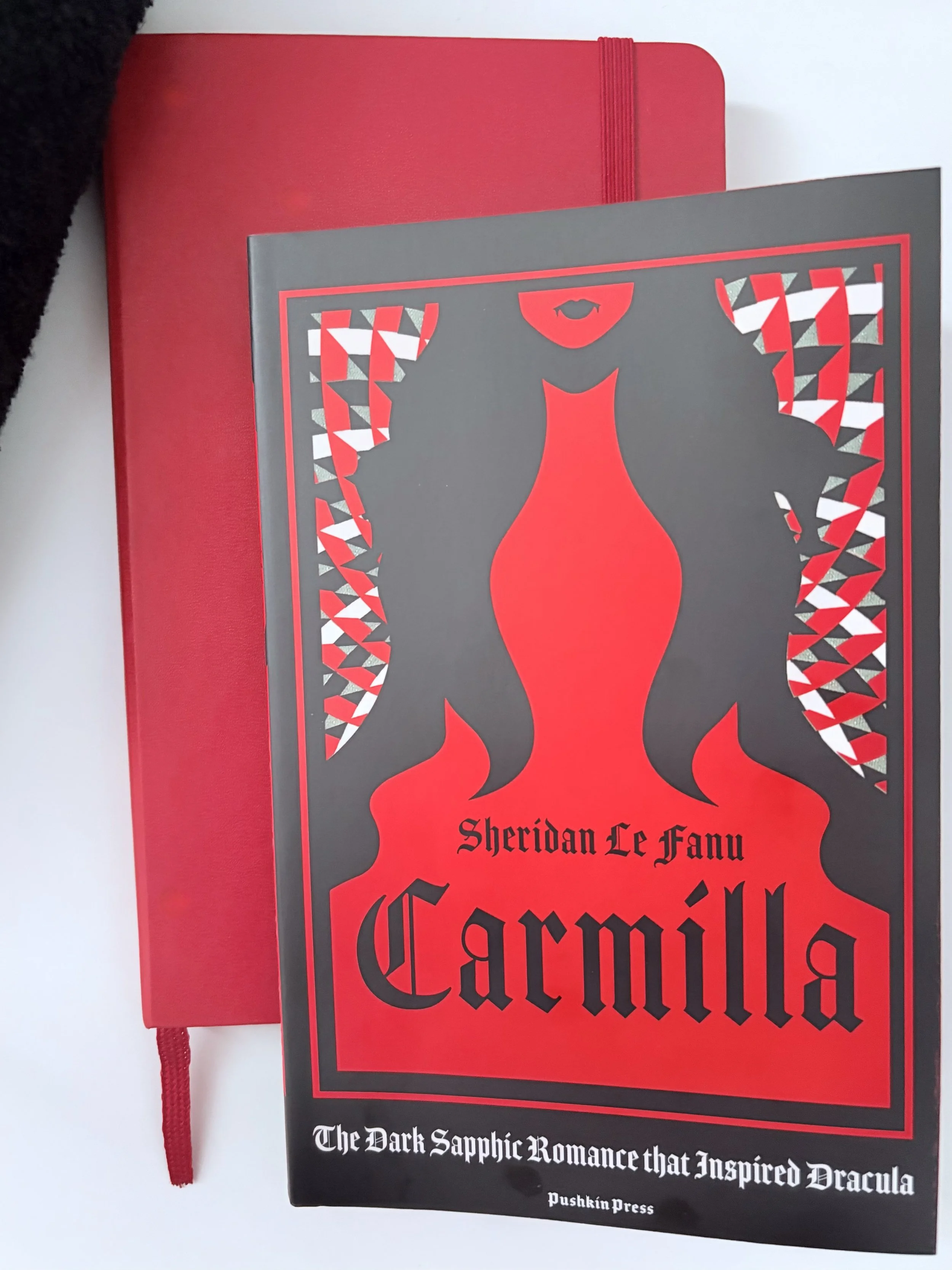 Carmilla - Sheridan Le Fanu on top of red notebook