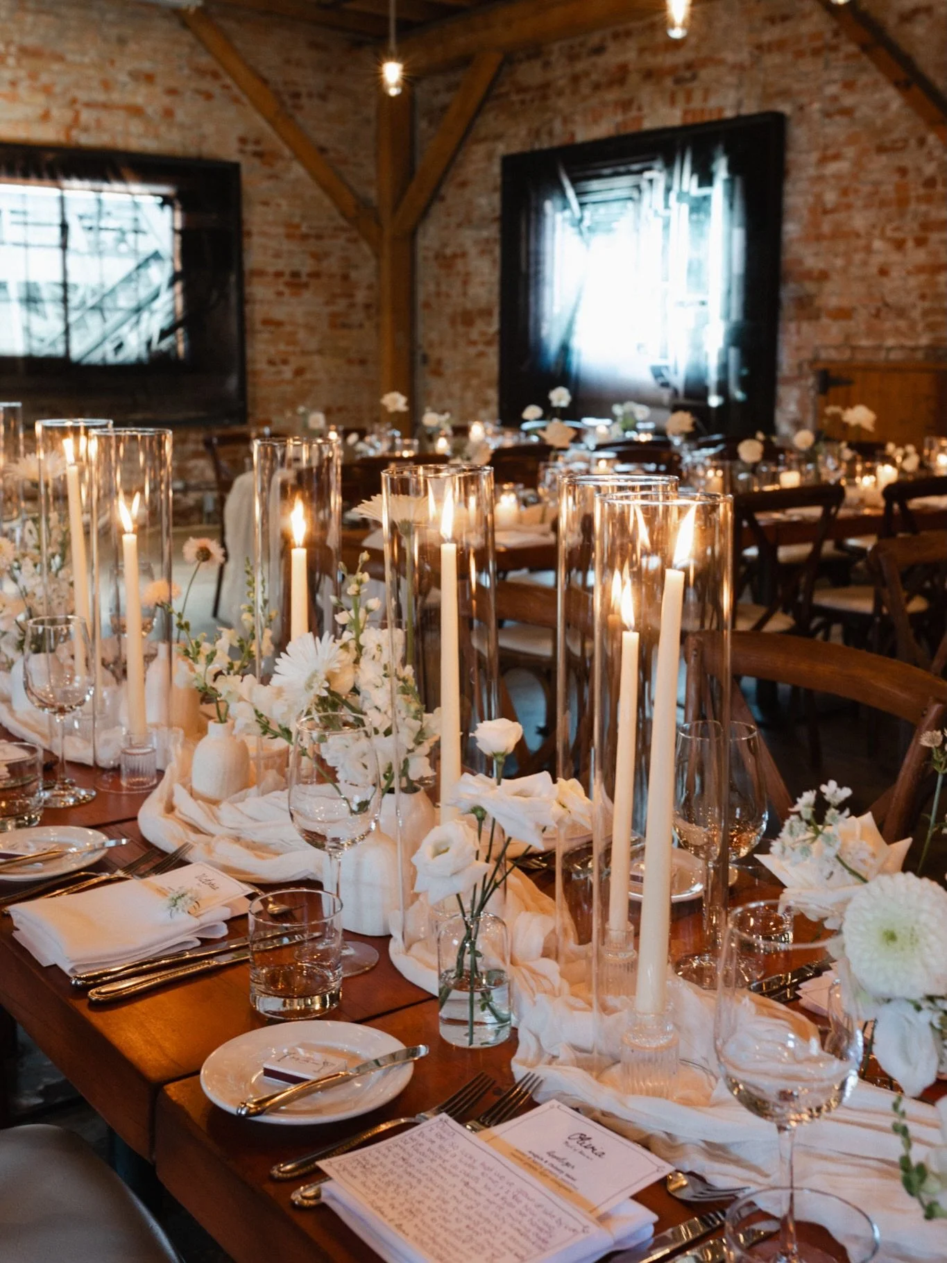 Archeo&rsquo;s brick-lined courtyard and warm industrial interior set the stage for a timeless all-white wedding design. 

Sculptural summer blooms, airy bud vases, and soft candlelight layered across long harvest tables created a romantic yet modern